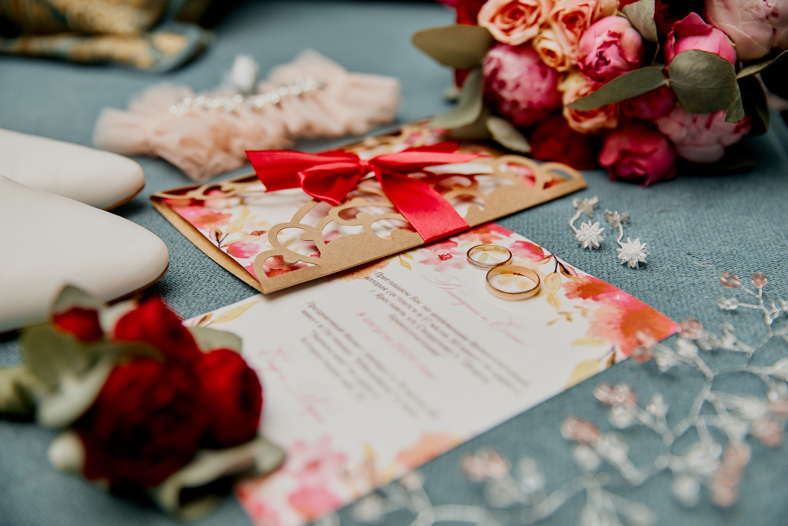 красивая композиция из обручальных колец, пригласительных на свадьбу и бижутерии 