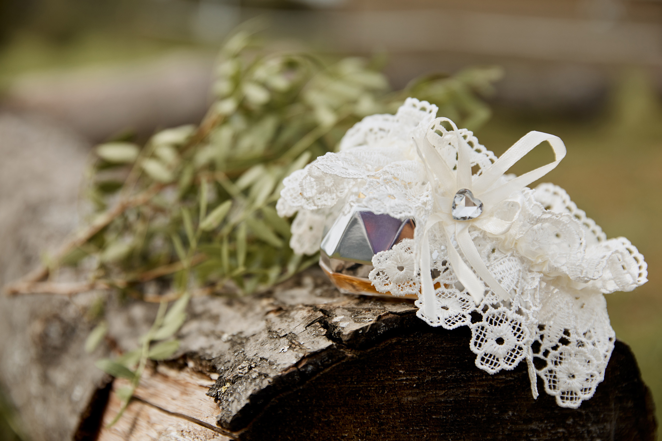 белая подвязка невесты на деревянном бревне