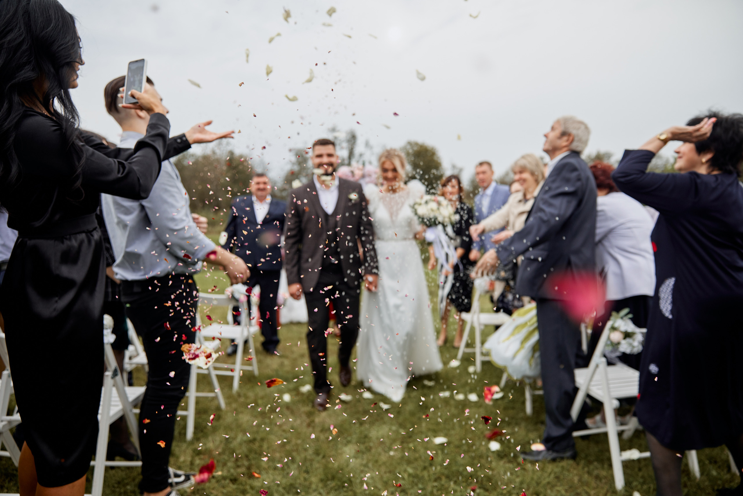 гости кидают лепестки под ноги молодожёнам