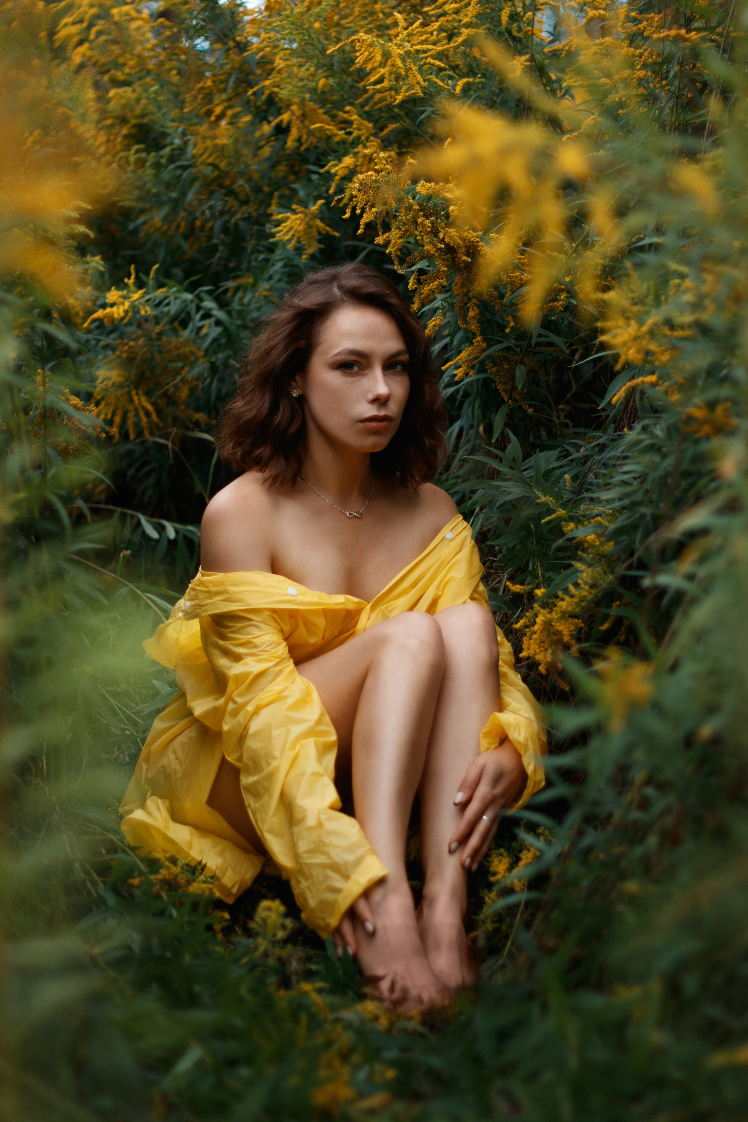 Полуголая девушка в желтом дождевике на природе.