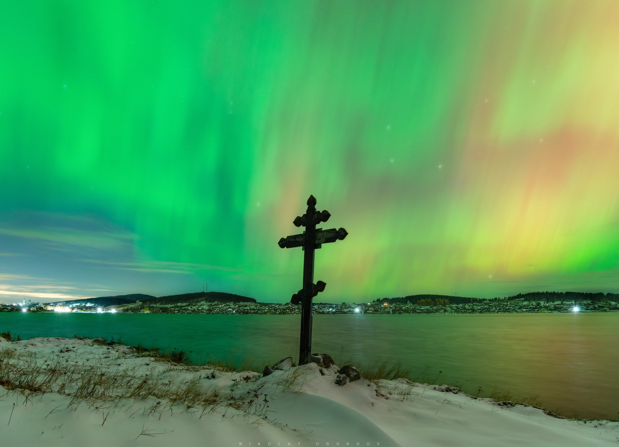 Крест на берегу пруда на фоне северного сияния  в поселке Черноисточинск (Средний Урал)