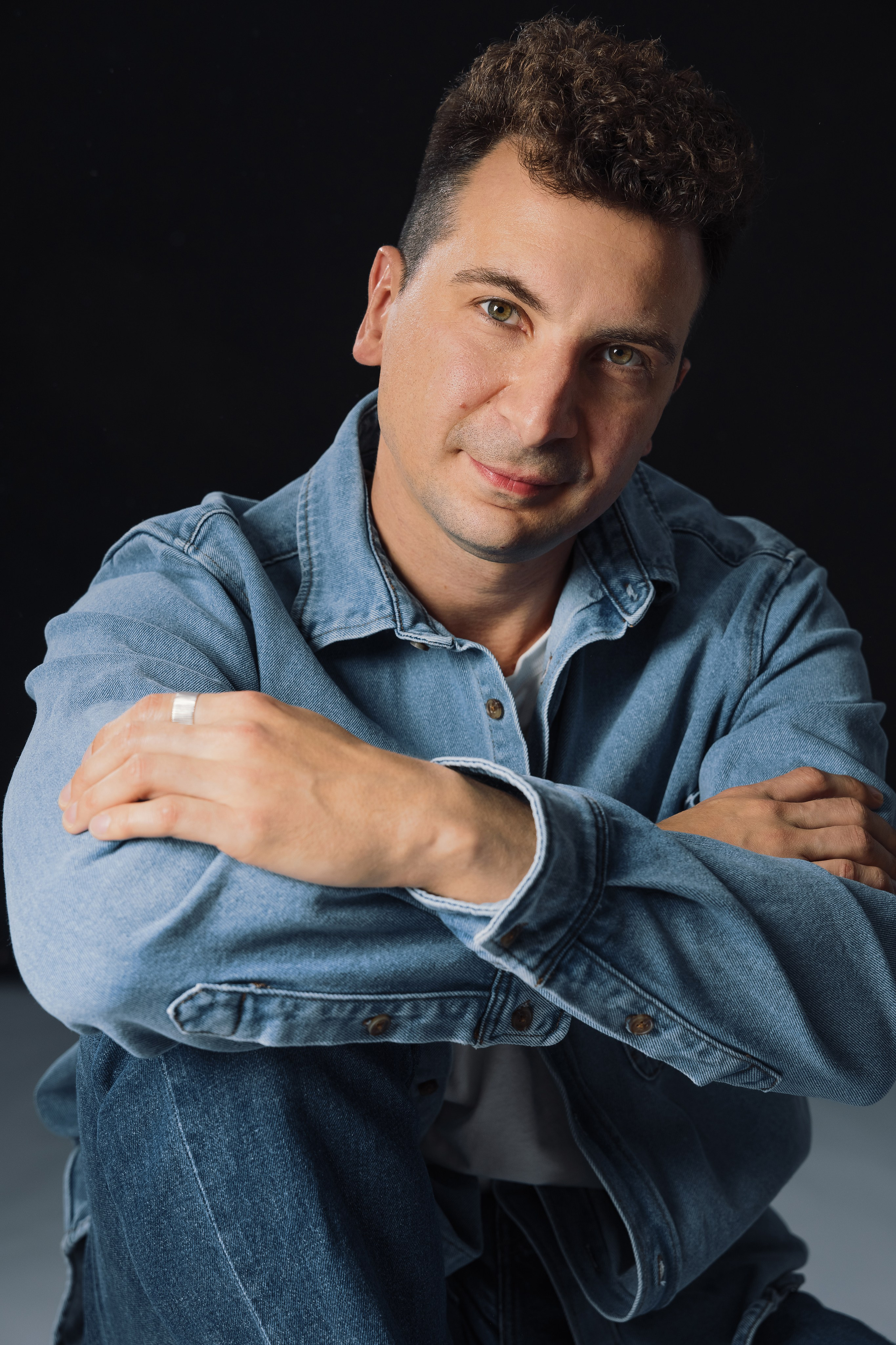 Портрет мужчины в джинсовой рубашке на темном фоне