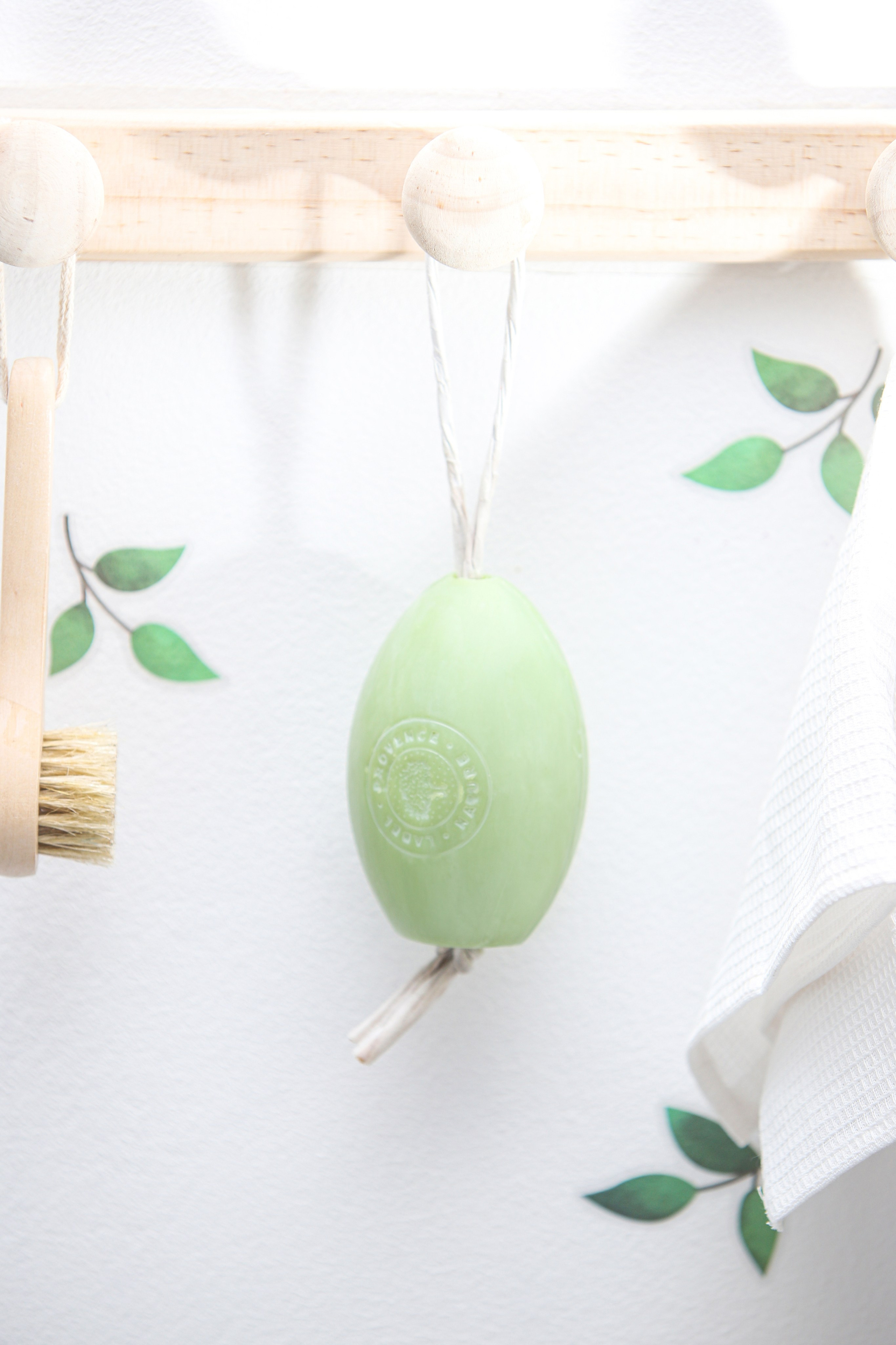 Фото зелёного овального мыла с верёвочкой — предметная съёмка.