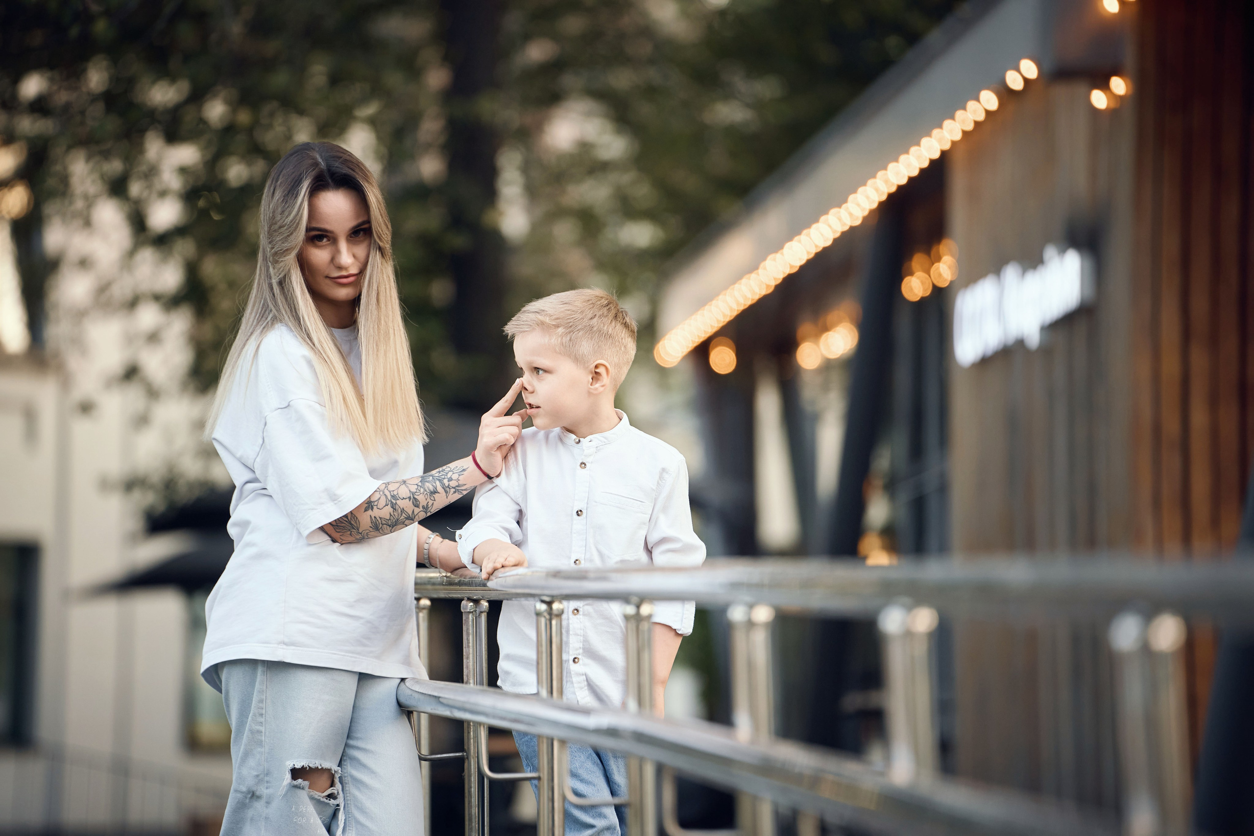 девушка и мальчик в белых рубашках и синих джинсах гуляют по территории ВДНХ в Москве