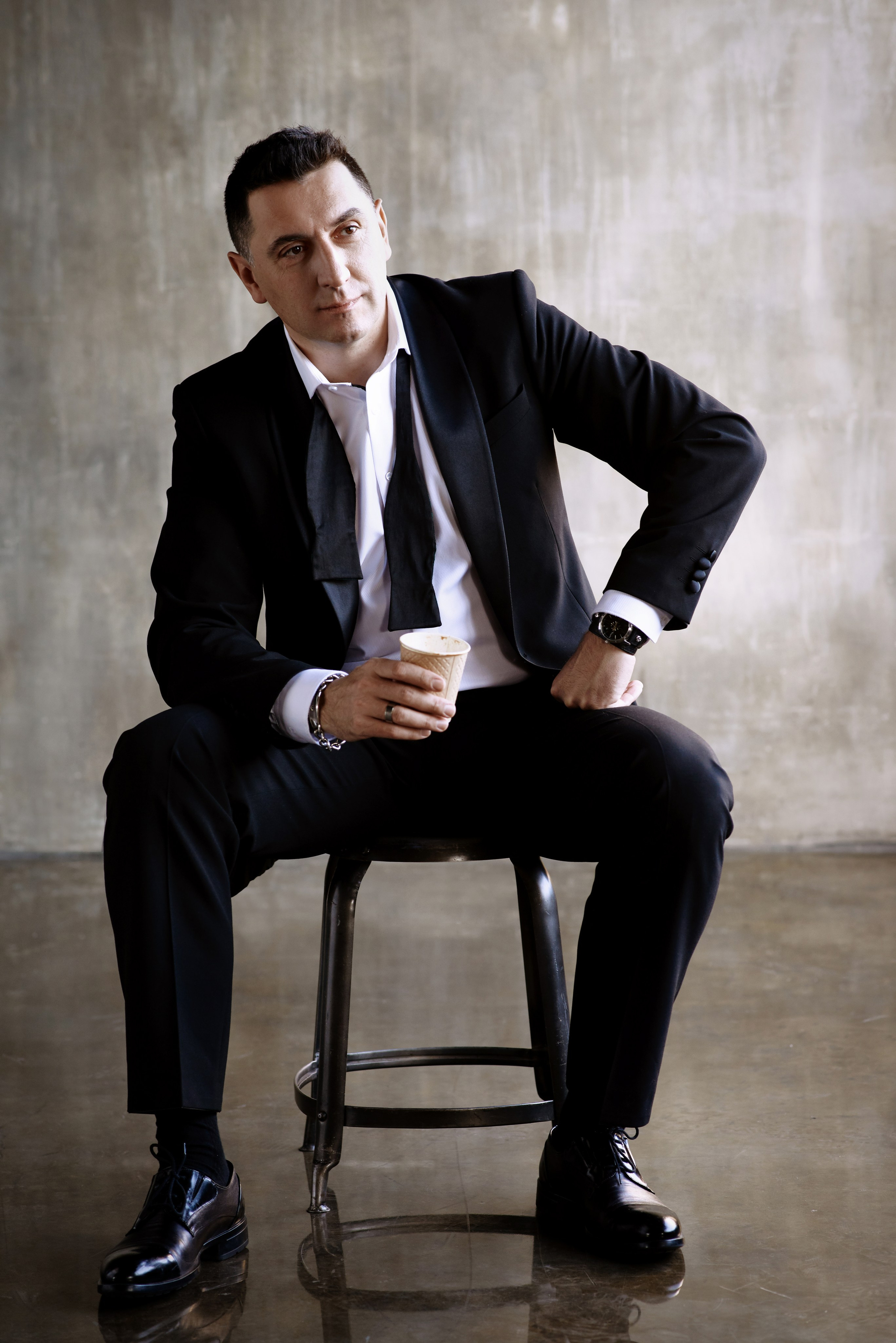 Фотосессия мужчины в расстегнутом галстуке бабочке и черном костюме