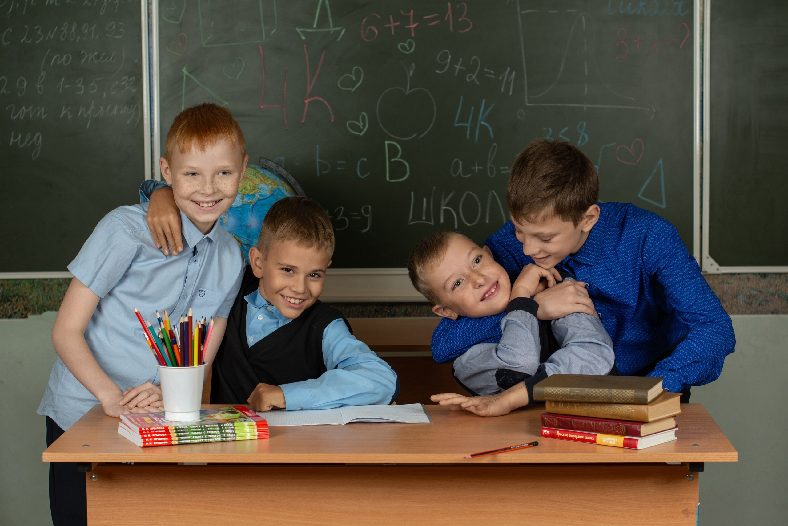 Дети весело бесятся на фотокамеру в классе.