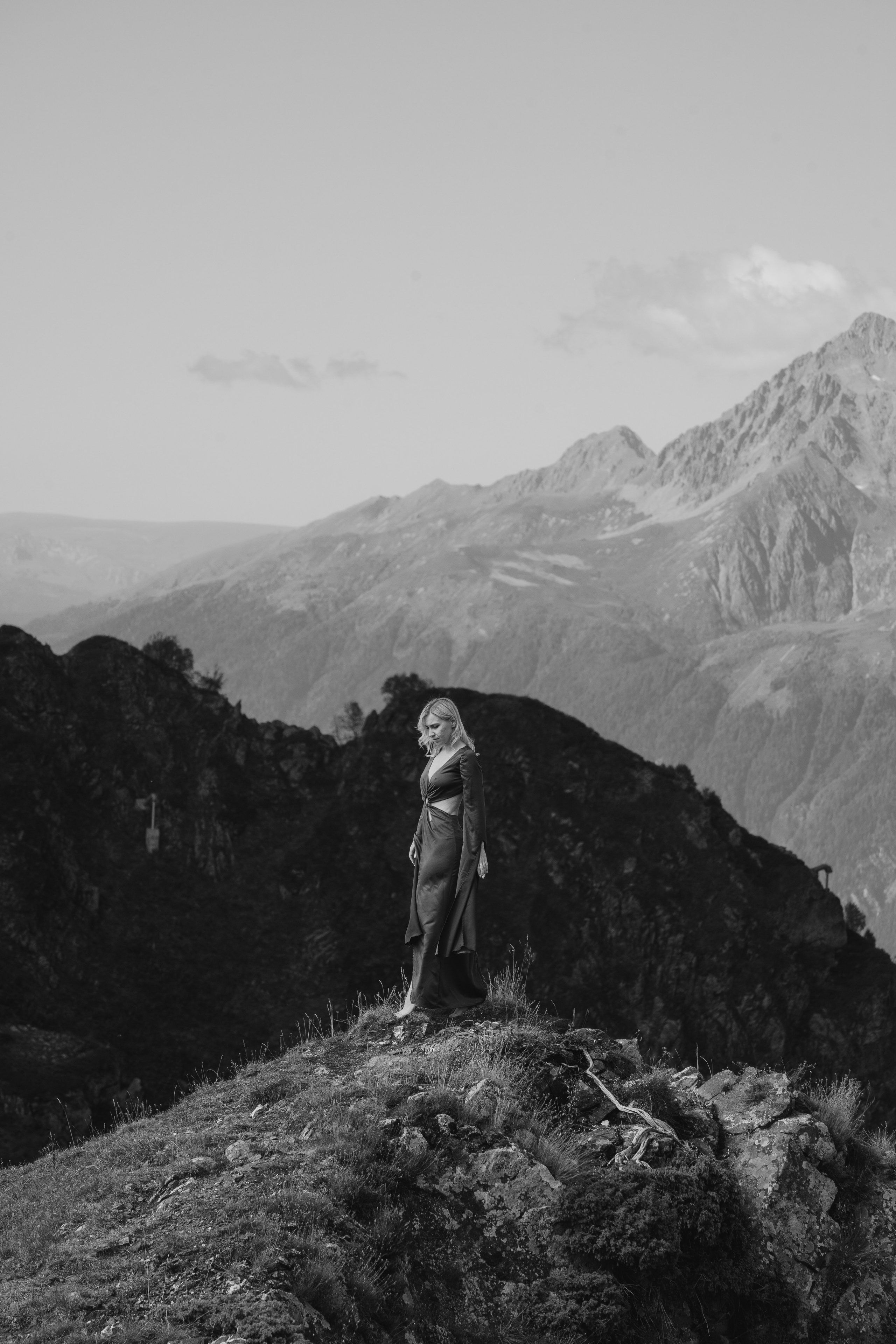 Общий кадр девушки на фоне горы стоящей над пропастью