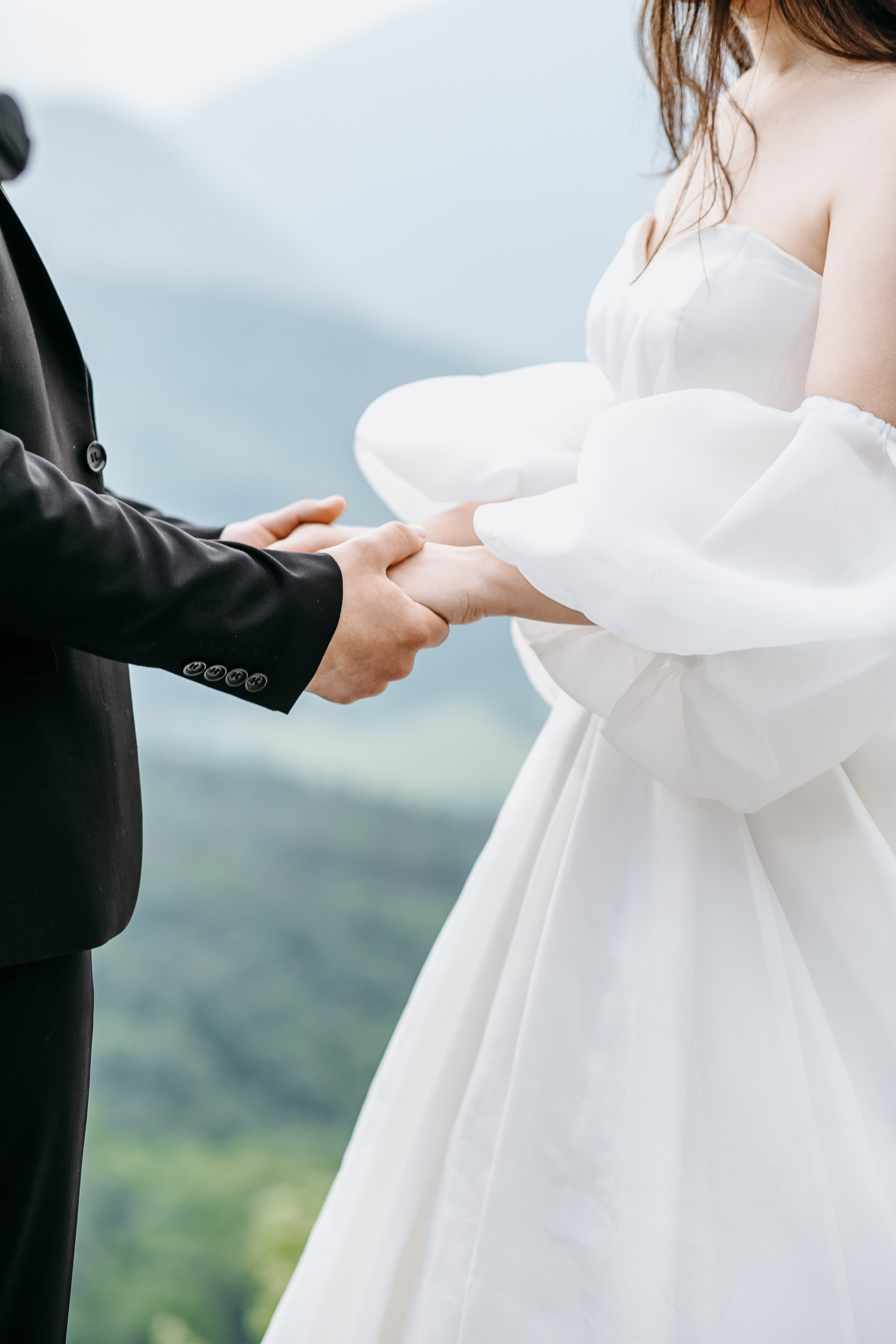 Необычные свадебные кольца, установленные на камне с живописными горными пейзажами на заднем плане