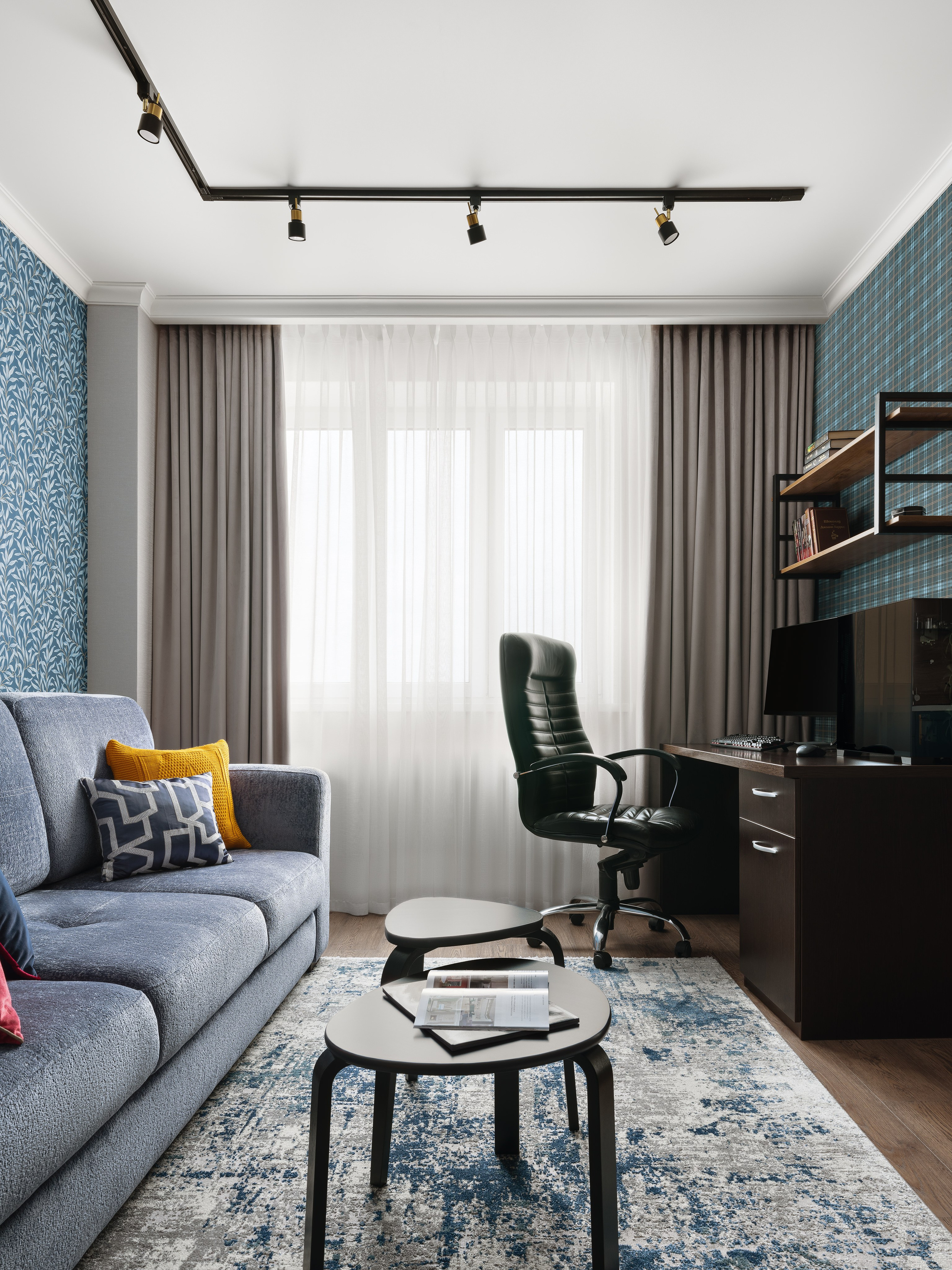 Современный дизайн интерьера гостиной с рабочим местом у окна, серым диваном и стильным декором. Фото подчеркивает уют, практичность и гармоничный стиль. Дизайнер Лилия Горожеева, фотограф Сергей Денисенко.