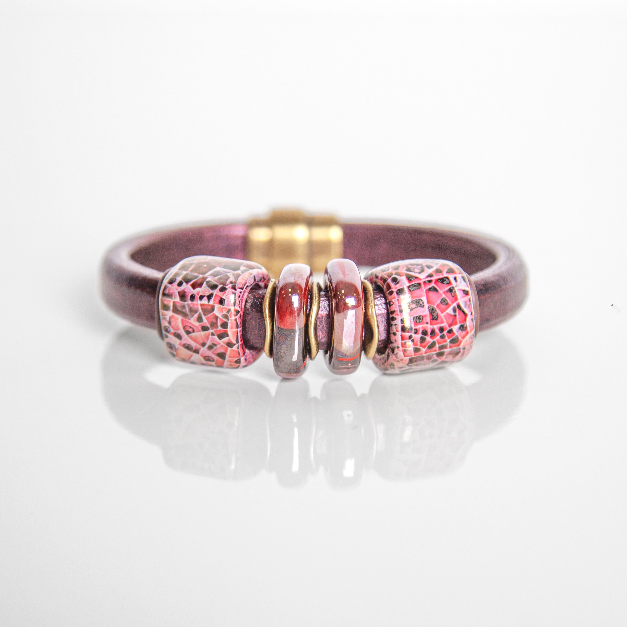 Кадр украшения на руку с леопардовым принтом, бордового цвета.