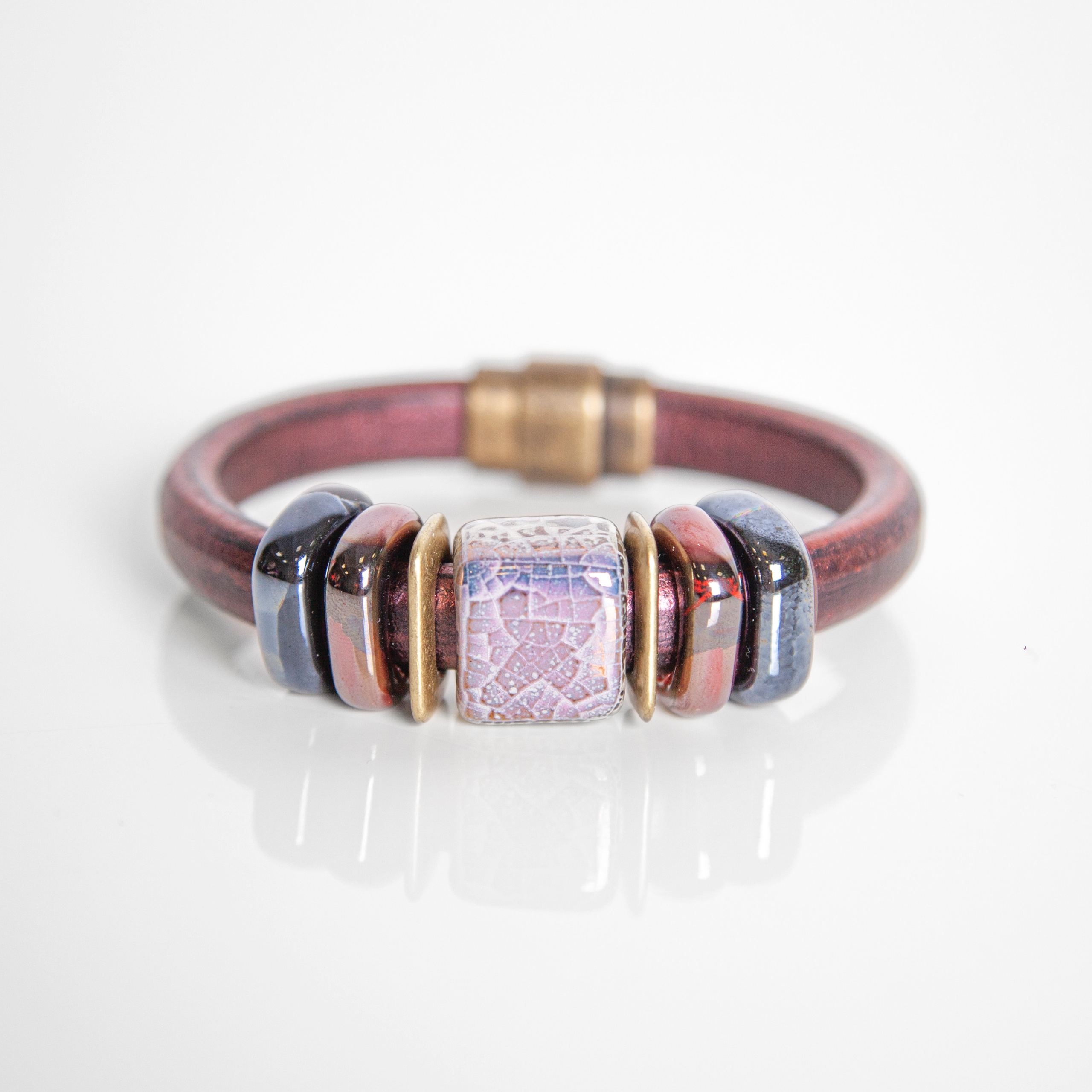 Фотография браслета с перламутровыми камнями и золотой застежкой.