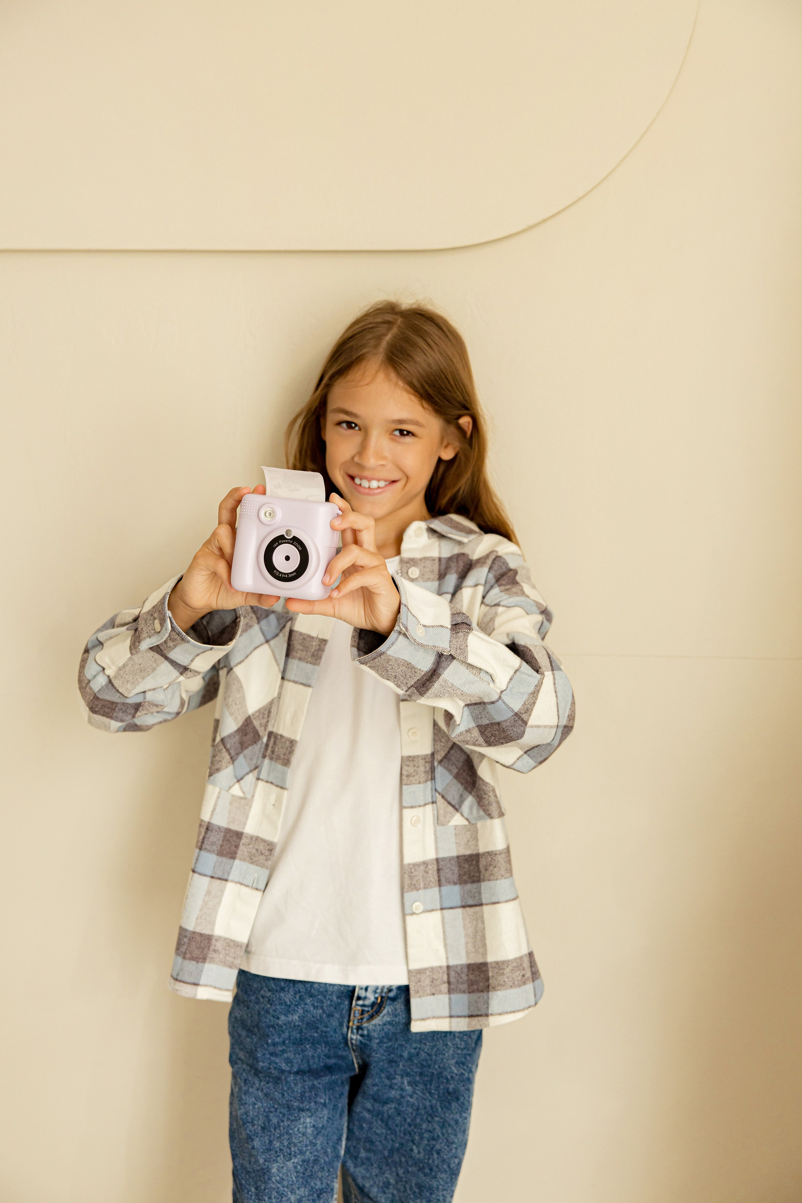 Девочка в рубашке рекламирует камеру моментальной печати