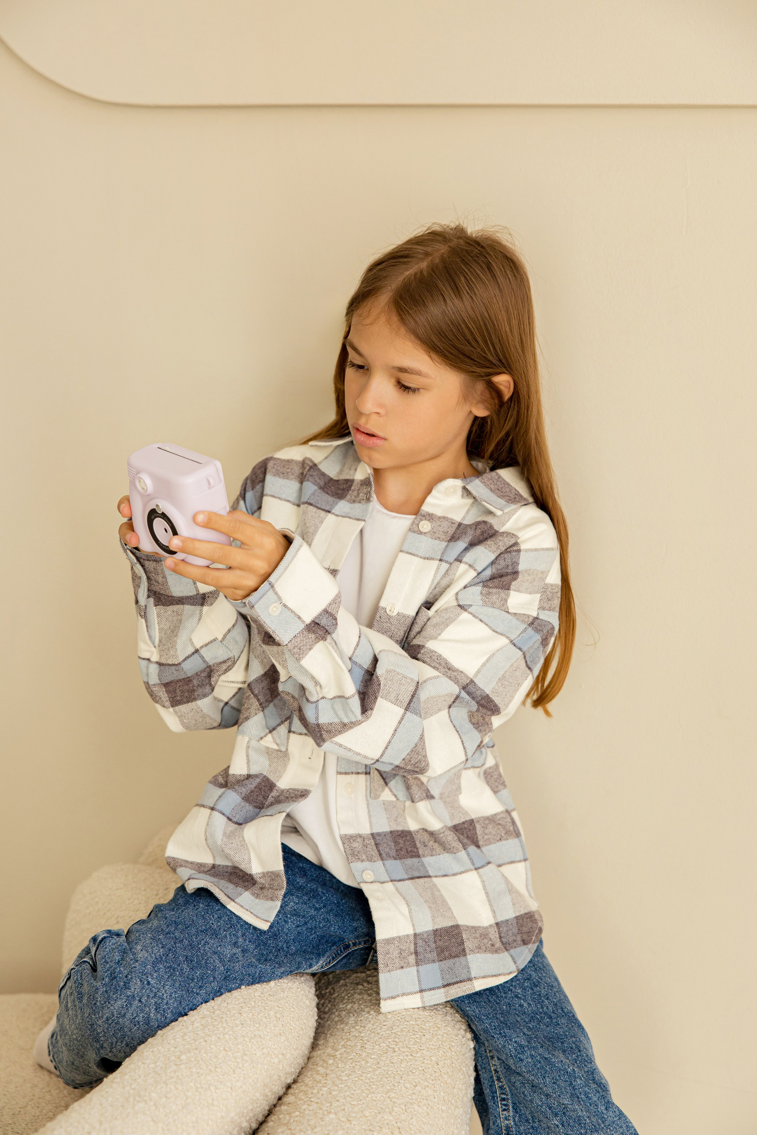 Девочка в рубашке с фотоаппаратом в руках