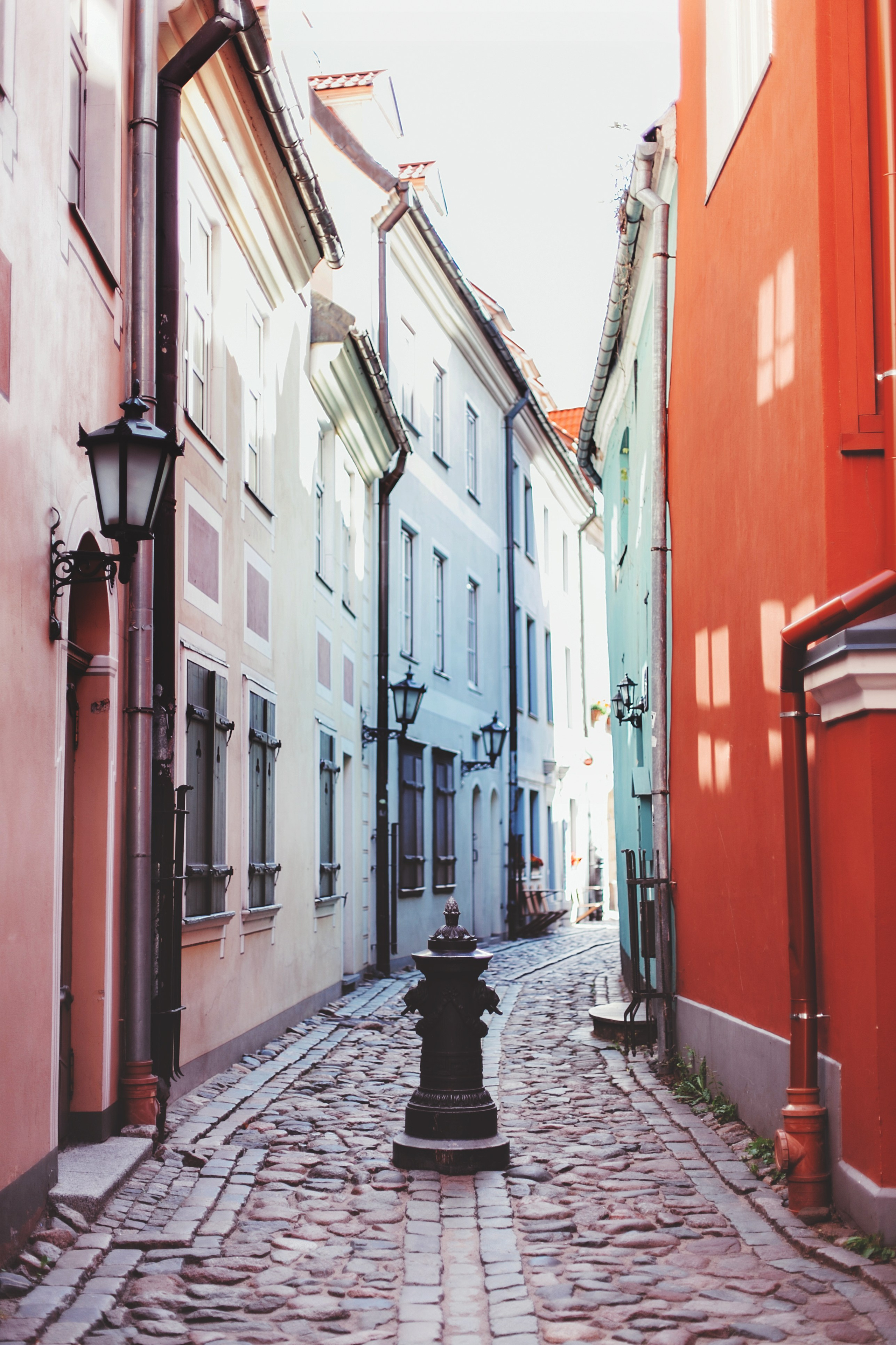 Очень узкая улица залитая солнцем в Риге