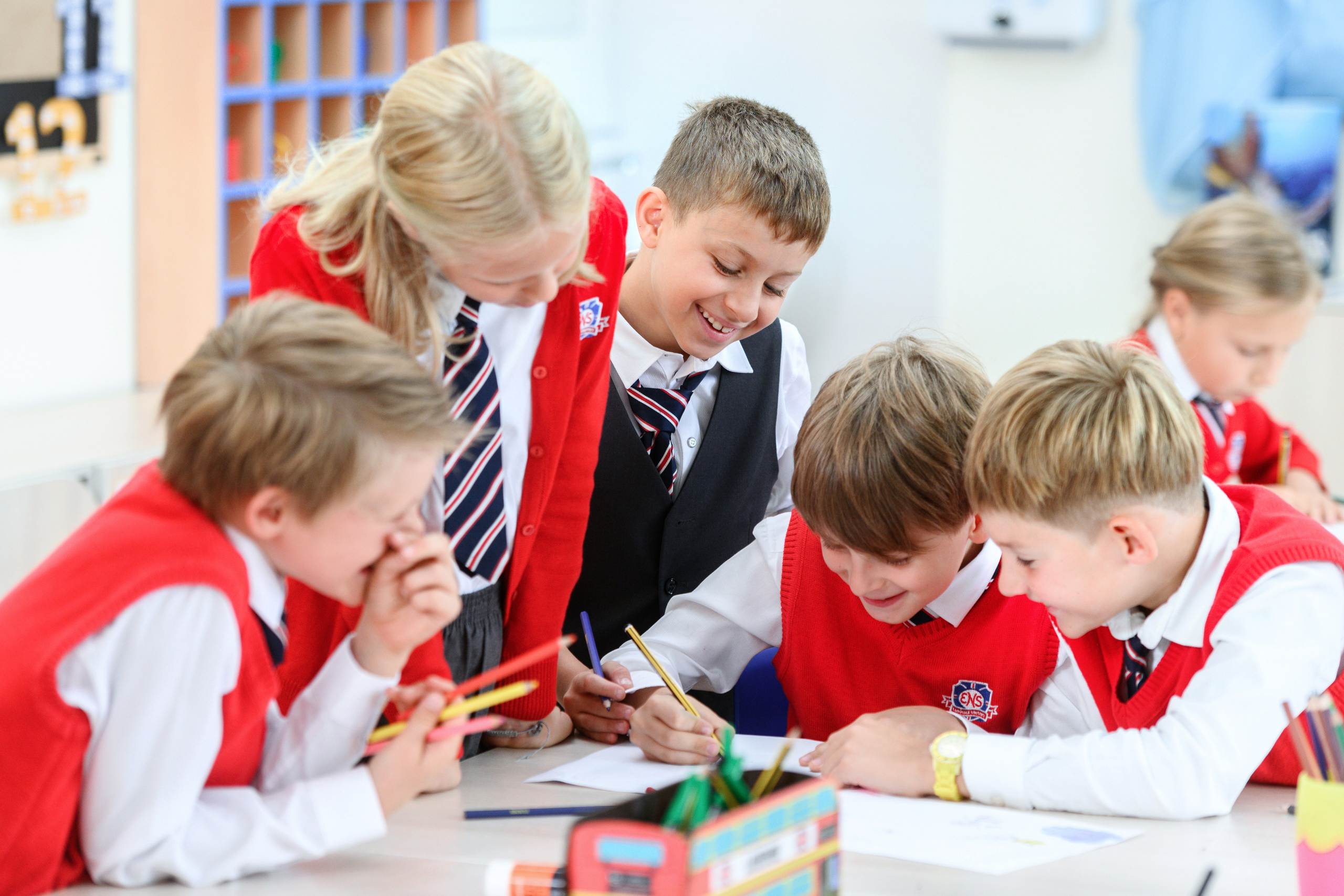 Группа школьников разбирает задание за партой. 