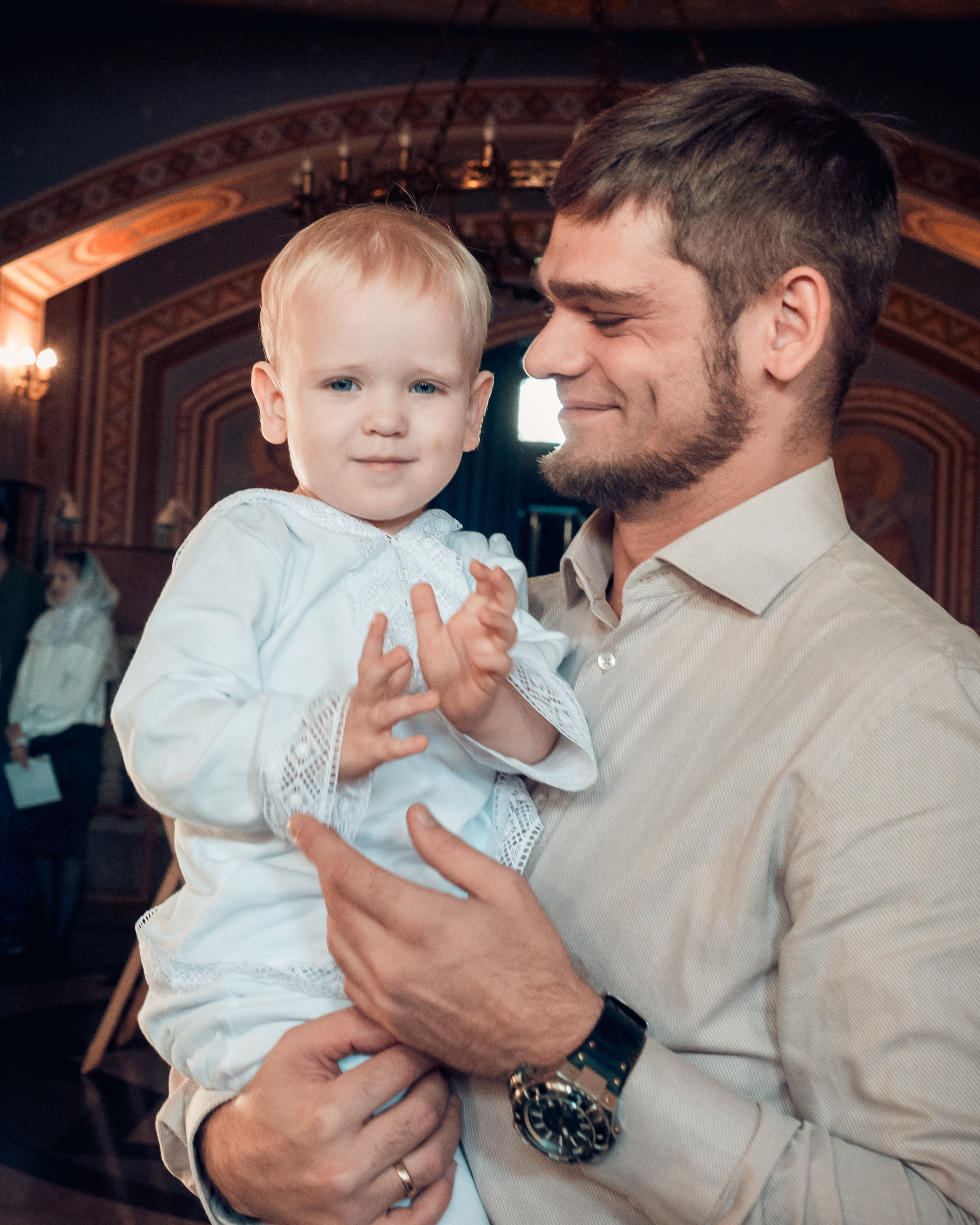 Счастливый отец с сыном после крещения, искренние эмоции в храме, семейный фотограф