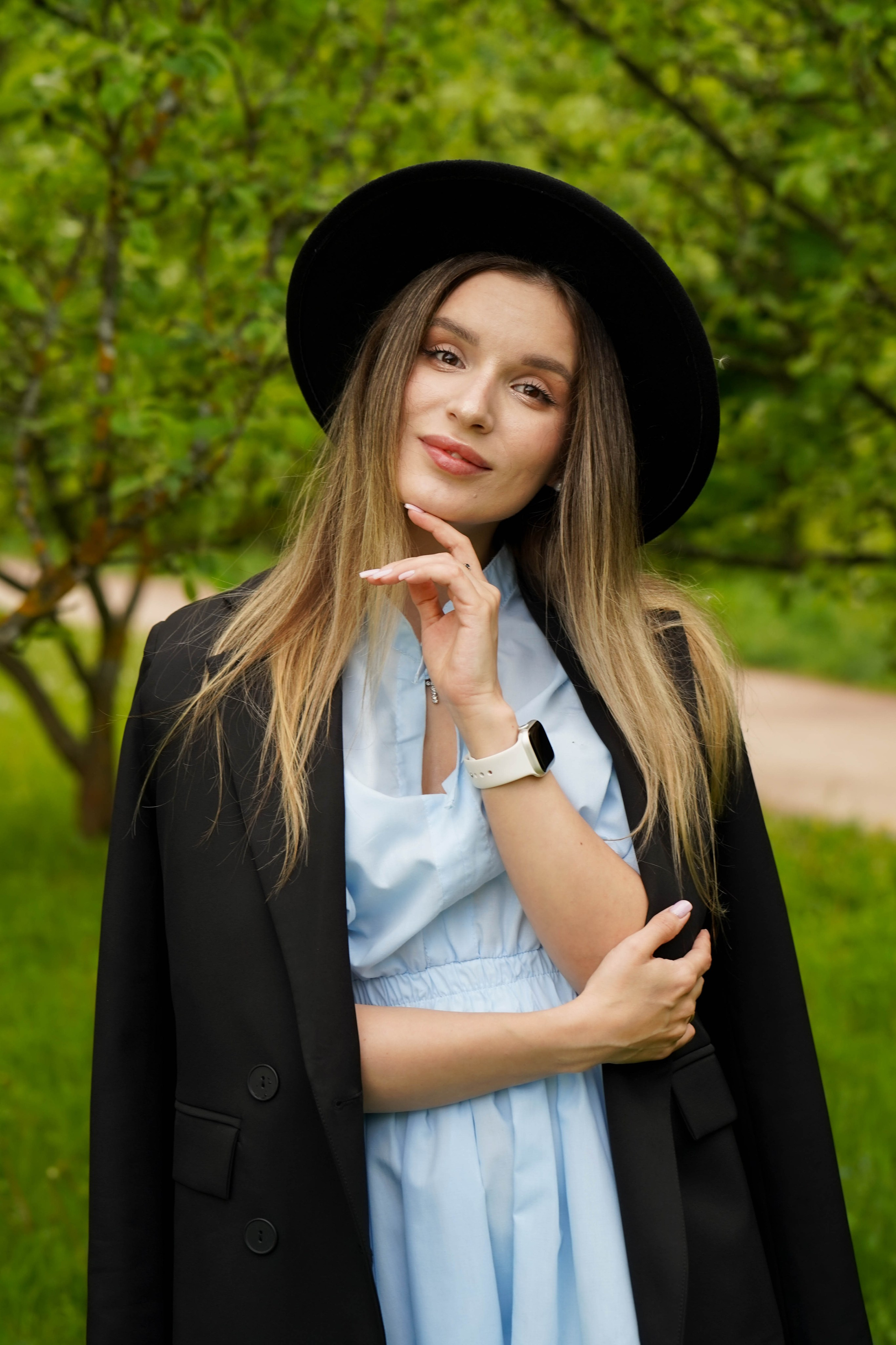 Девушка в черной шляпе на фоне зелени. Фотограф Анна Калинцева