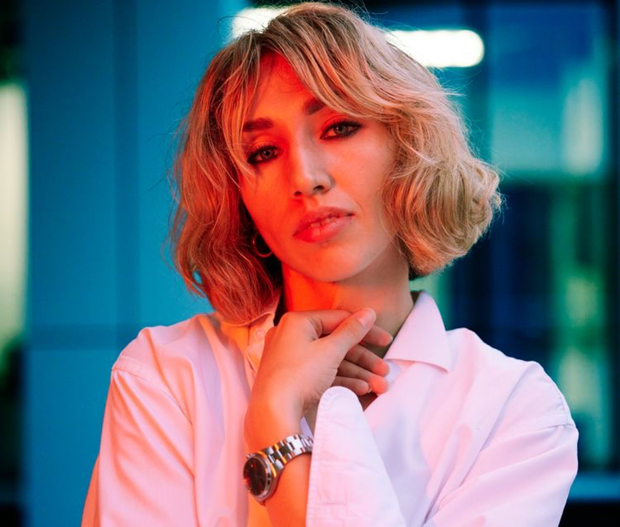 Location portrait of a young woman in red lighting against the backdrop of a building - photographer Andrey Dunin