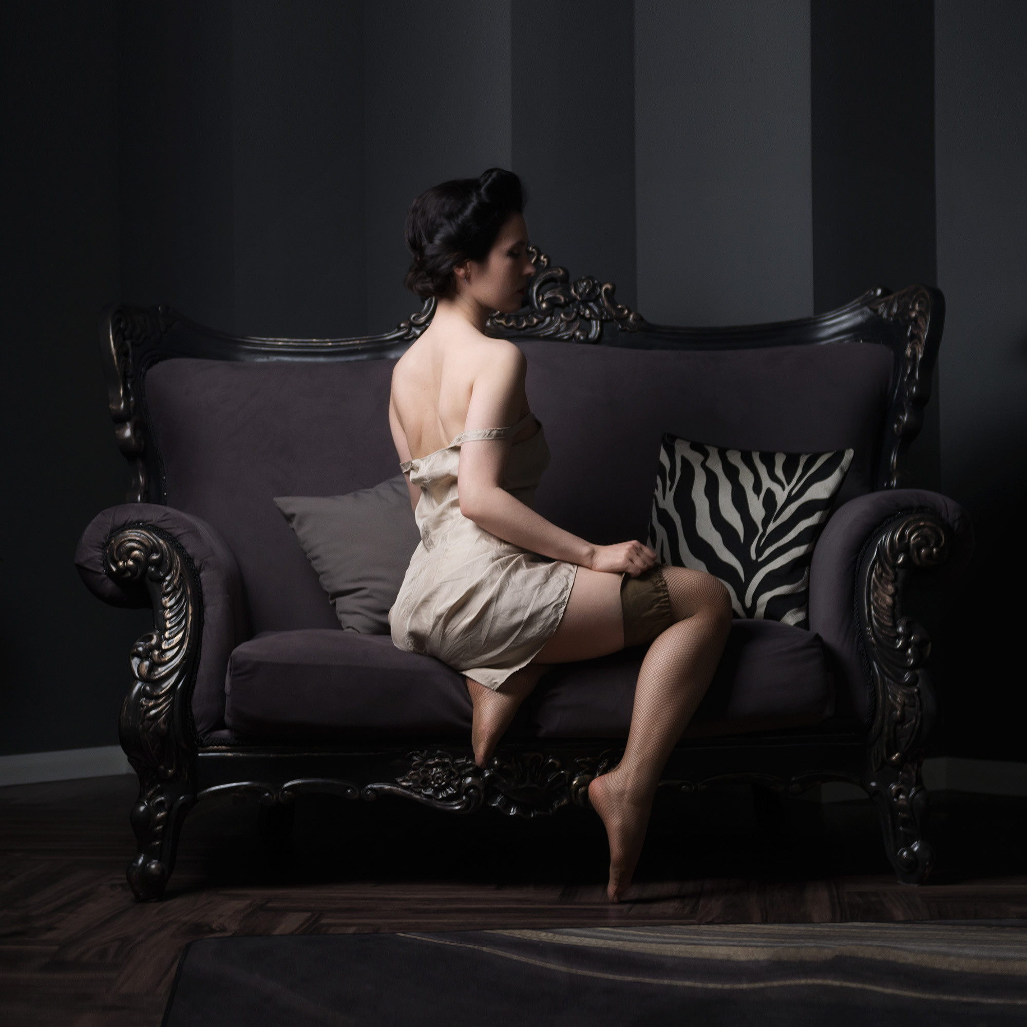 Девушка в нижней сорочке и чулках, винтажный стиль. Низкий ключ, вид со спины.