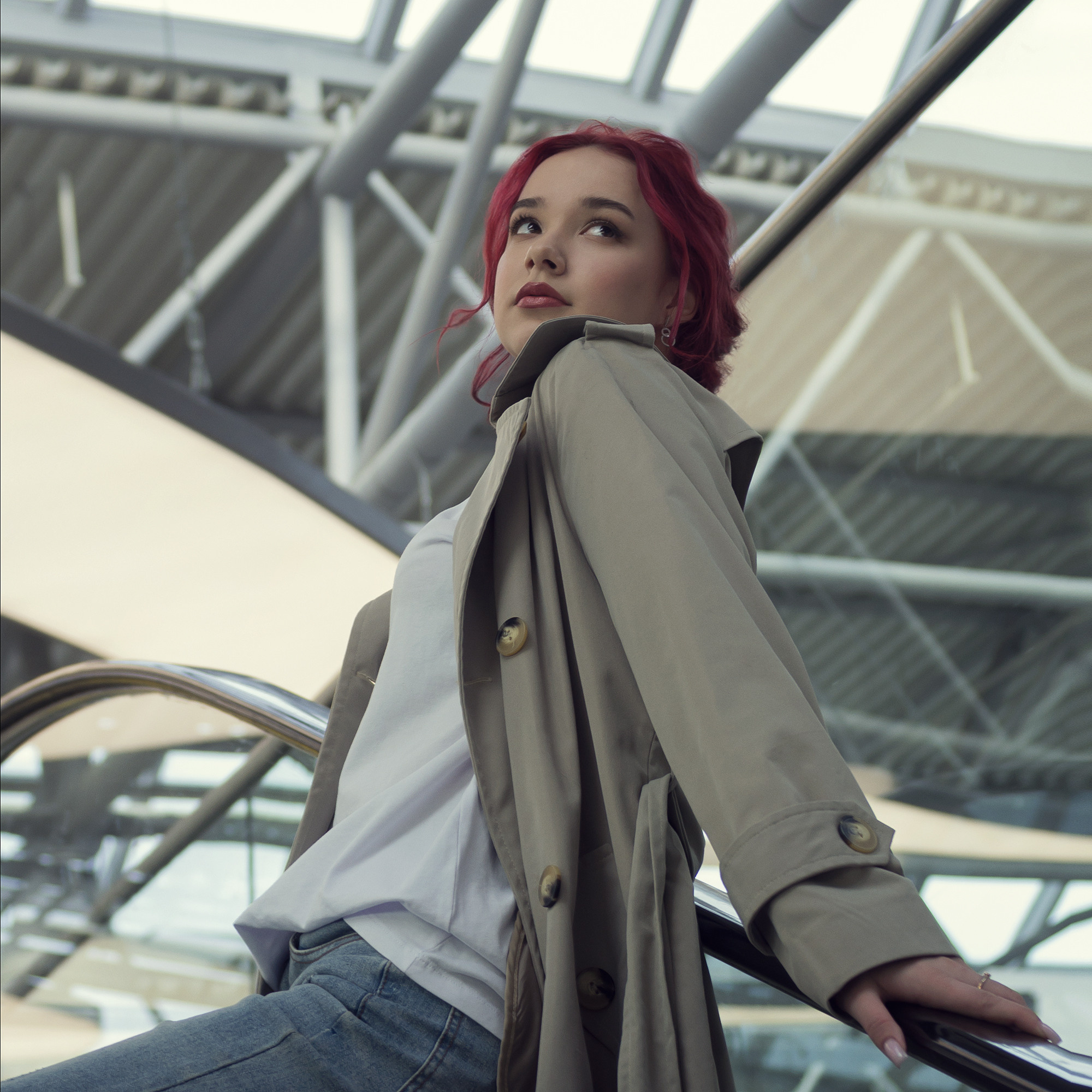 Портрет рыжей девушки в плаще. Вид снизу.