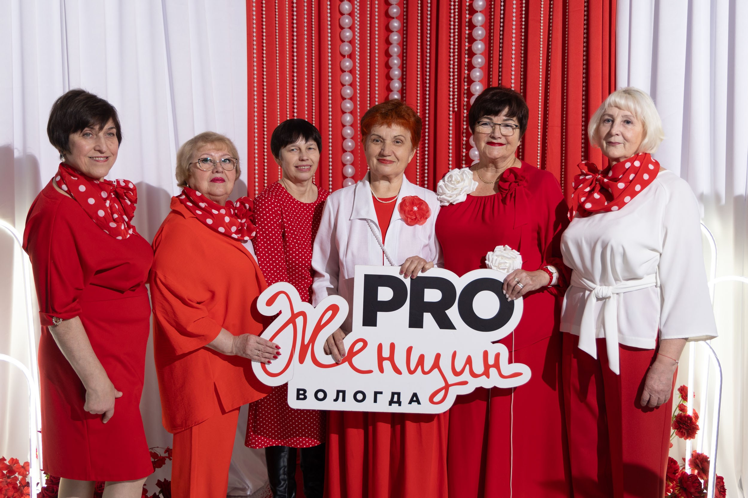 Группа из женщин в красно-белой гамме.