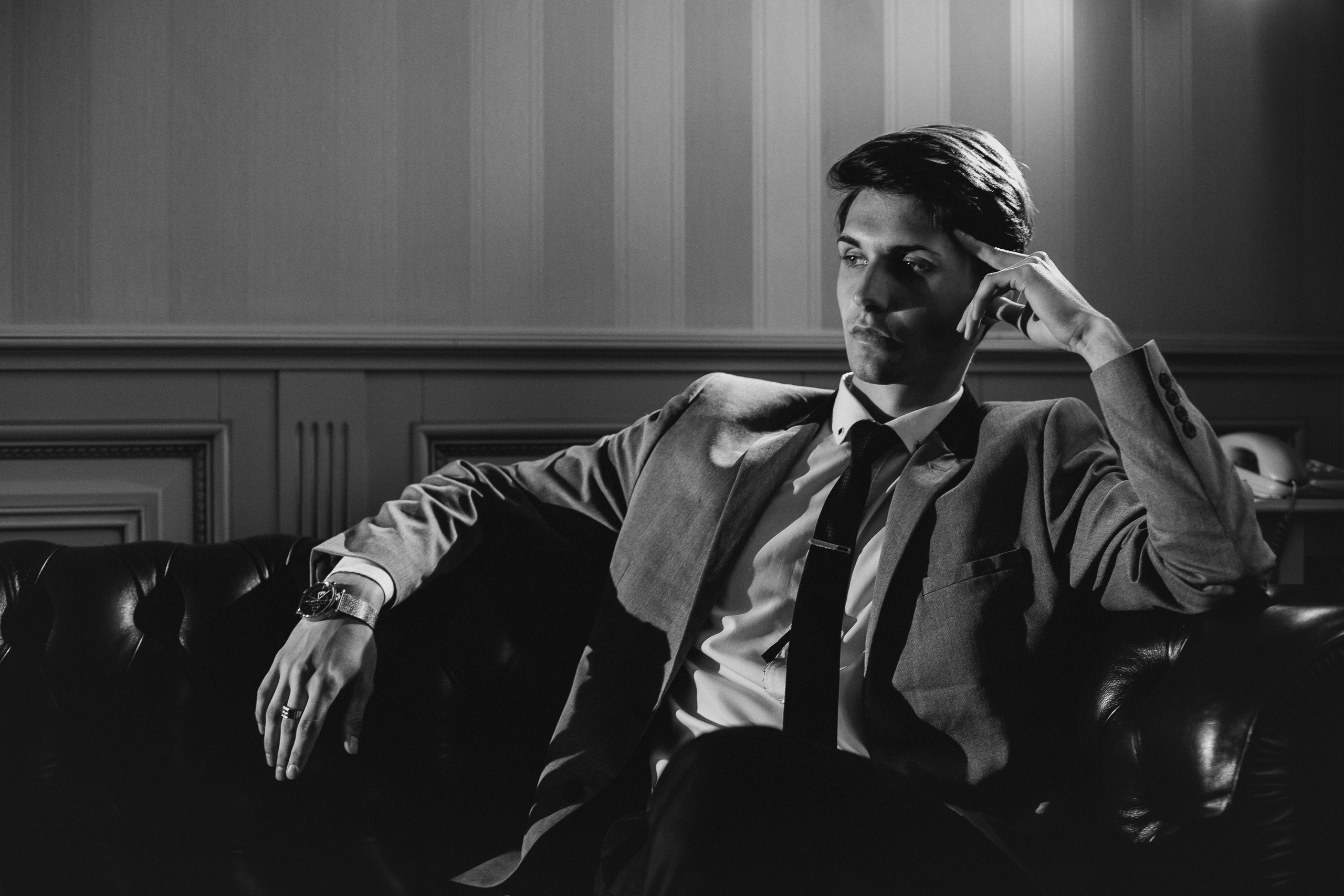 Жених сидит на диване. Черно белая фотография