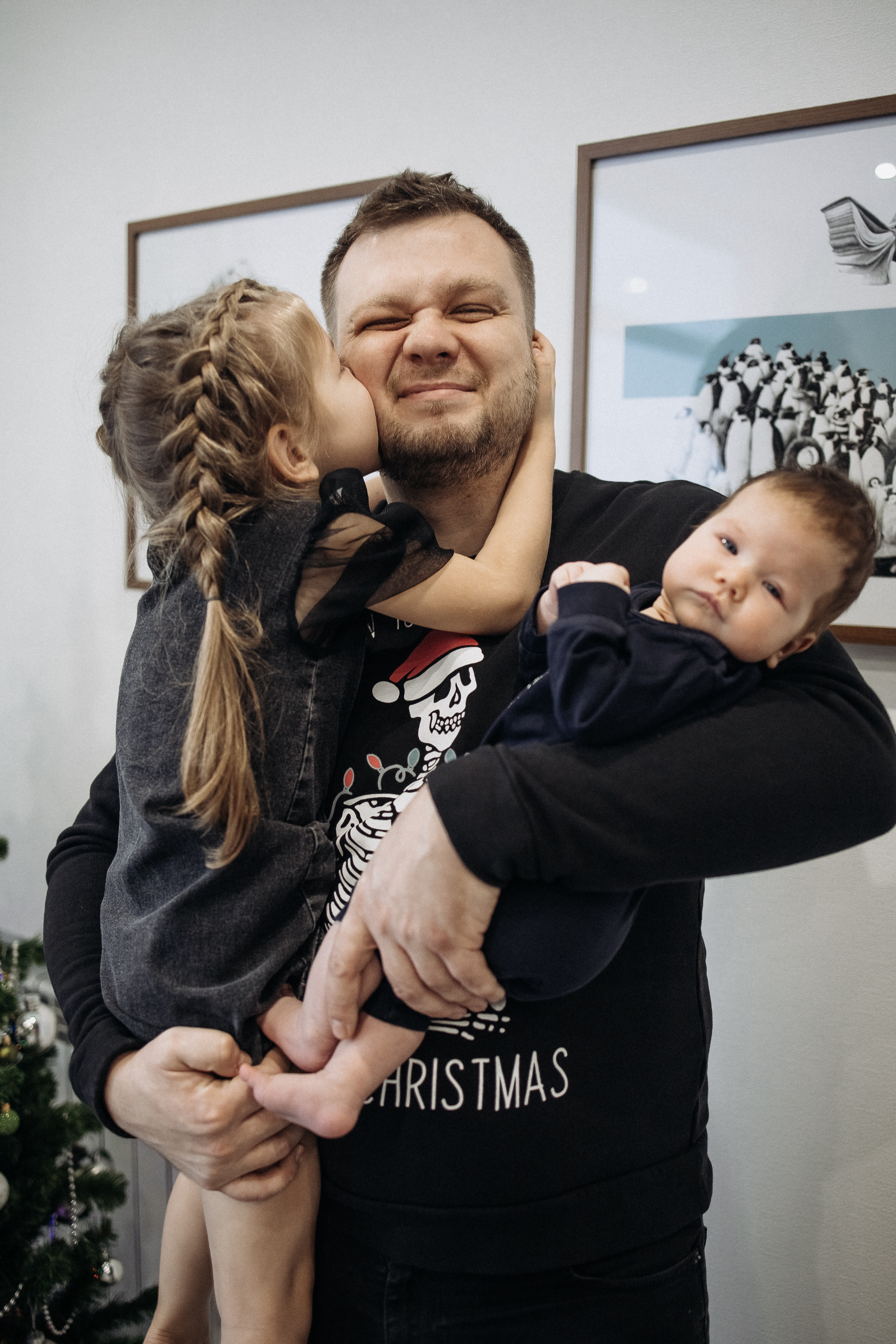 Папа держит на руках двух своих дочек. Домашняя фотосессия