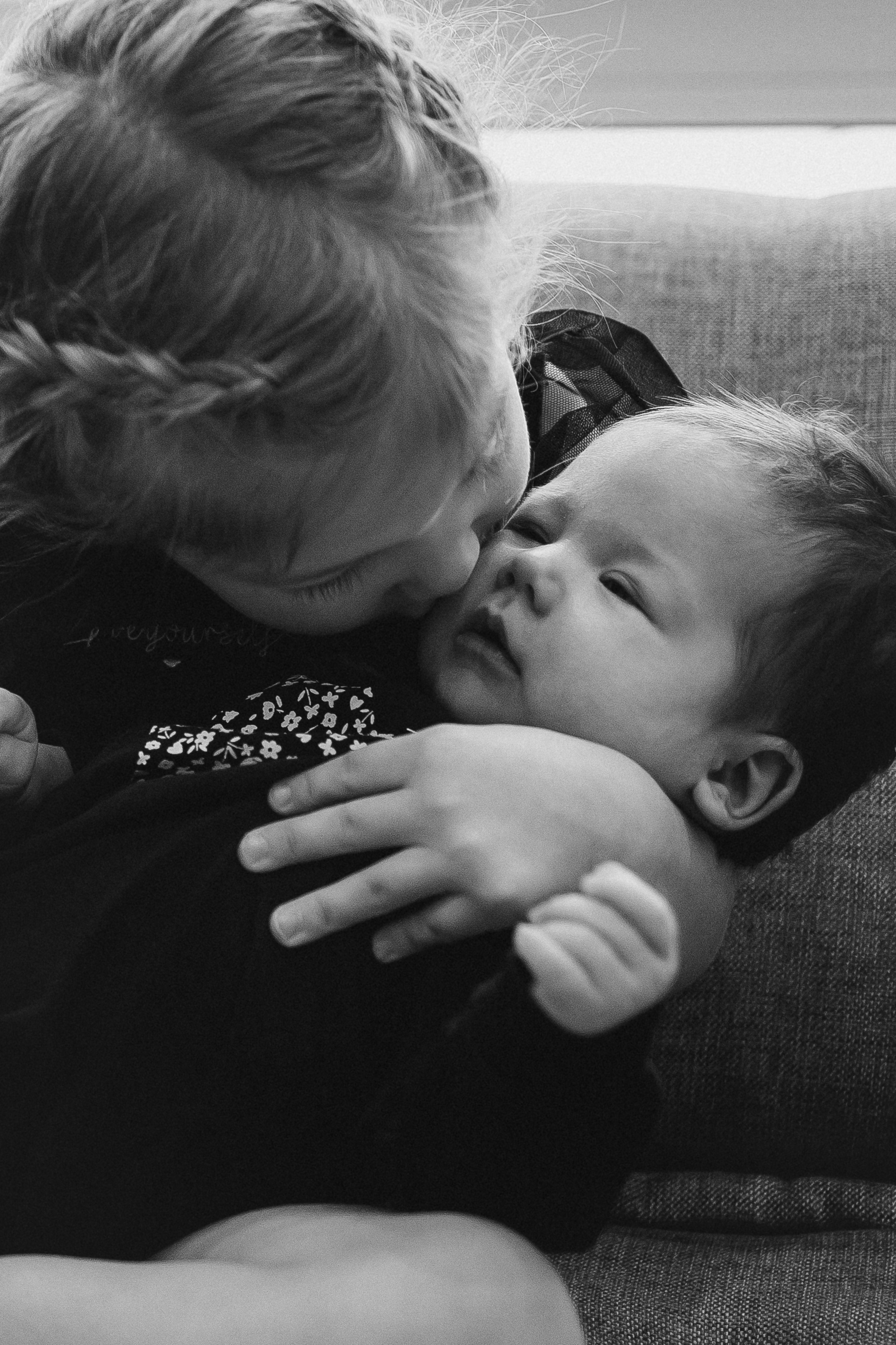 Старшая сестренка целует младшую сестру