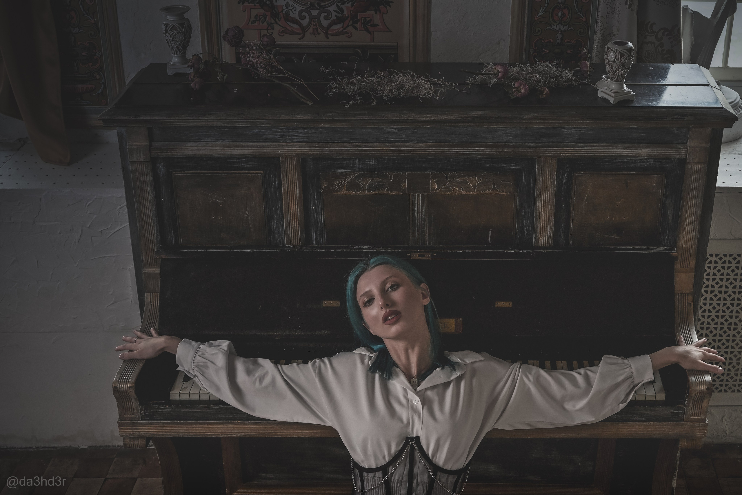 Девушка с синими волосами лежит на фортепиано