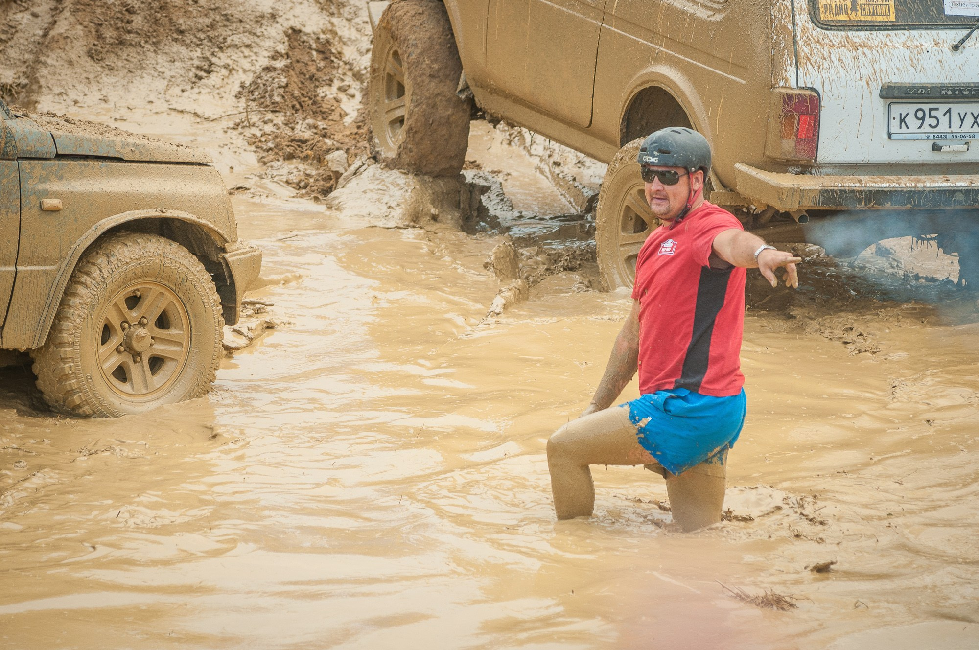 Водитель застрявшего автомобиля указывает другим водителям где лучше проехать