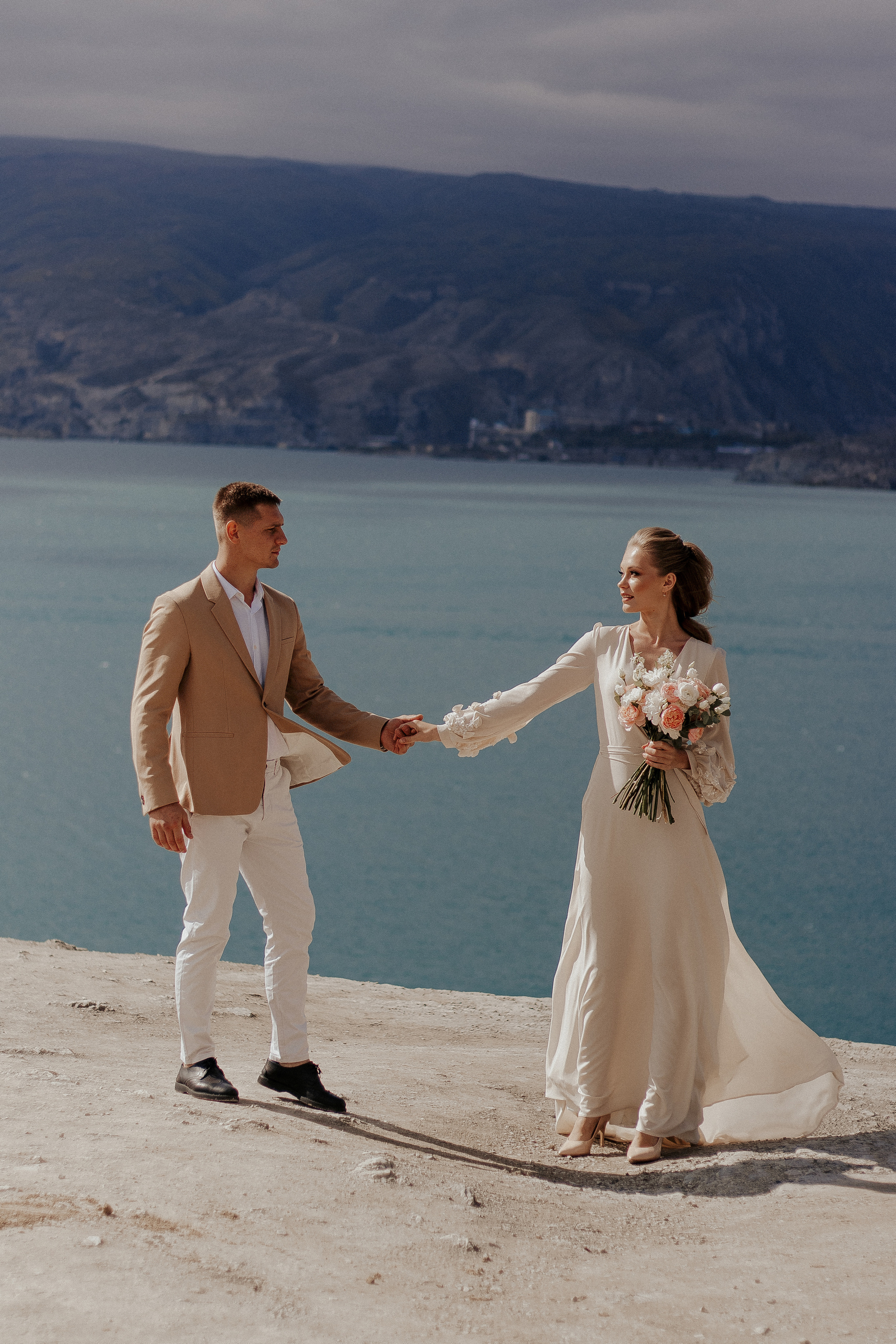 Пара на берегу озера держится за ручку — свадебная фотосессия у озера в Дагестане