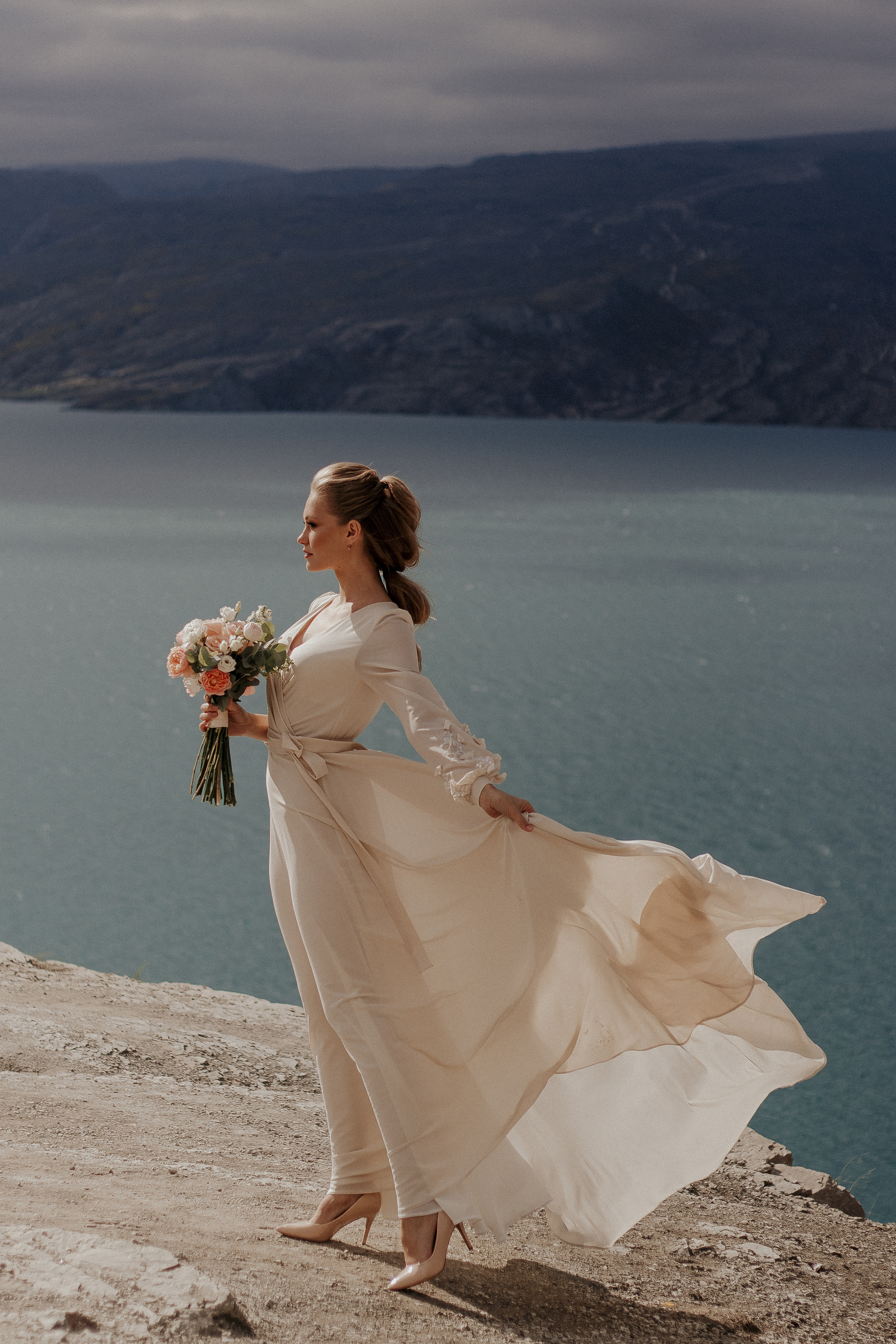 Невеста в летящем платье с букетом — свадебная фотосессия у озера в Дагестане