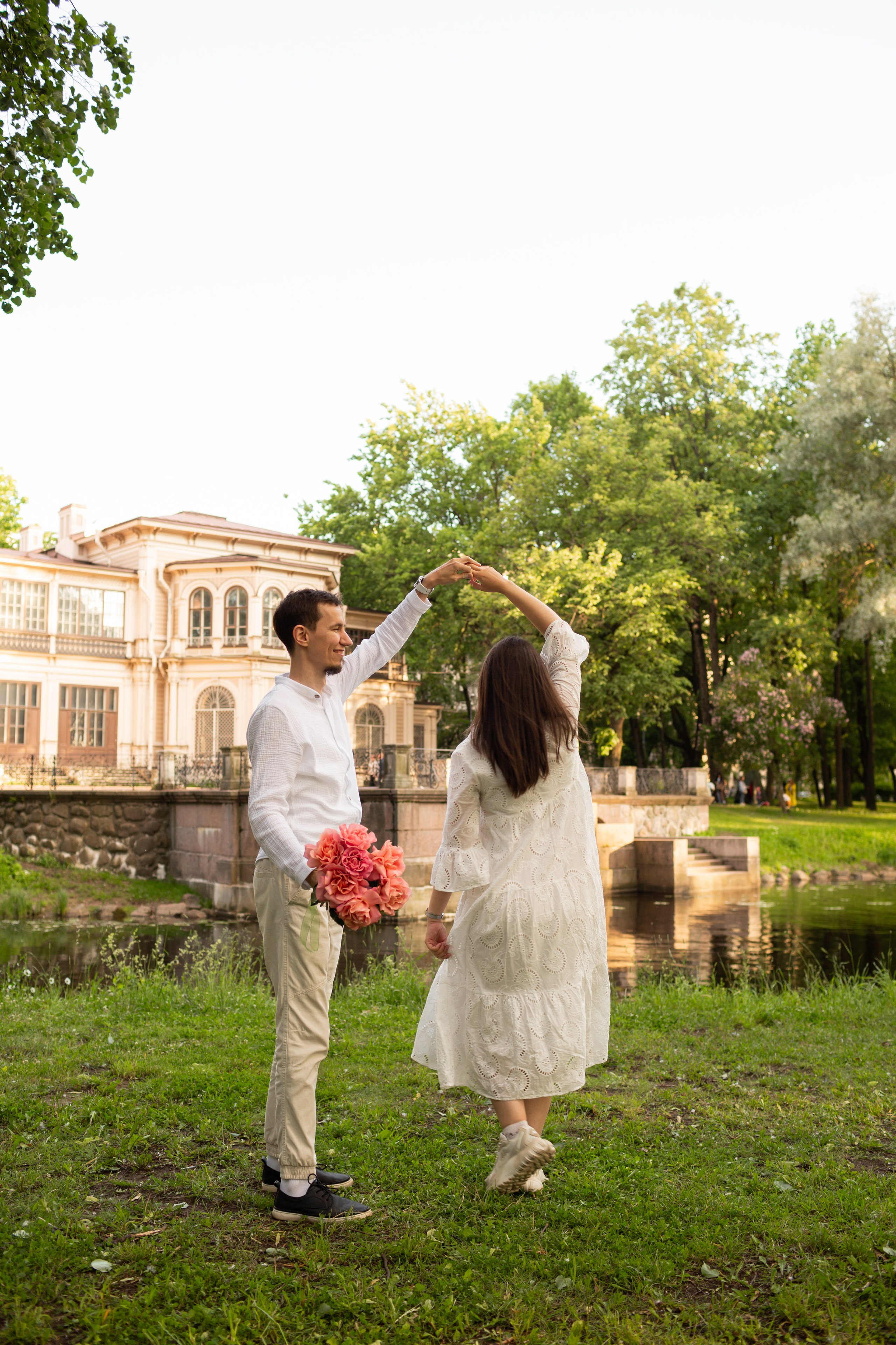 Счастливые будущие родители на прогулке в саду.
