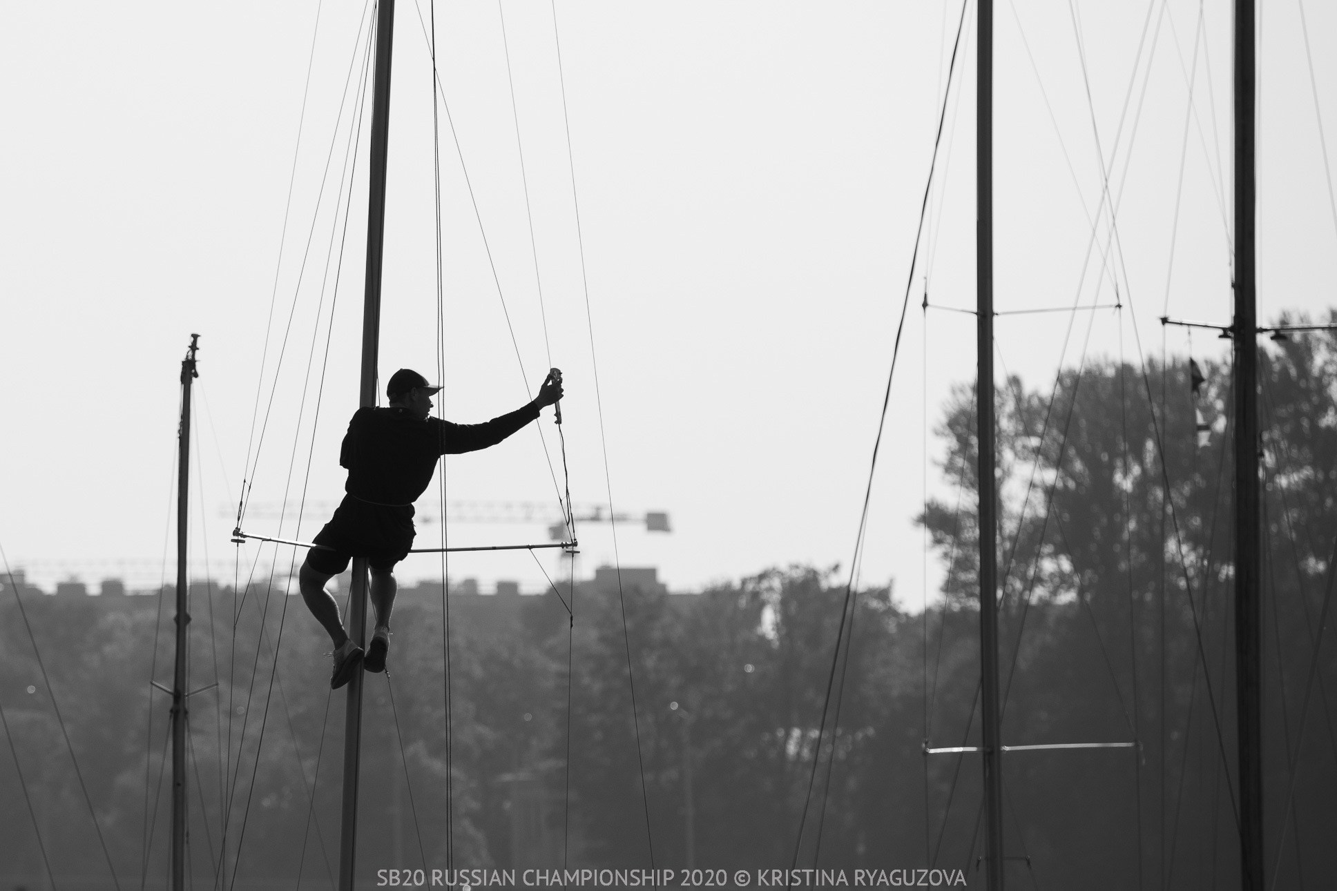 Яхтсмен в контровом свете во время подготовки яхт к гонкам на чемпионате России в классе яхт SB20. ЧБ фото.
