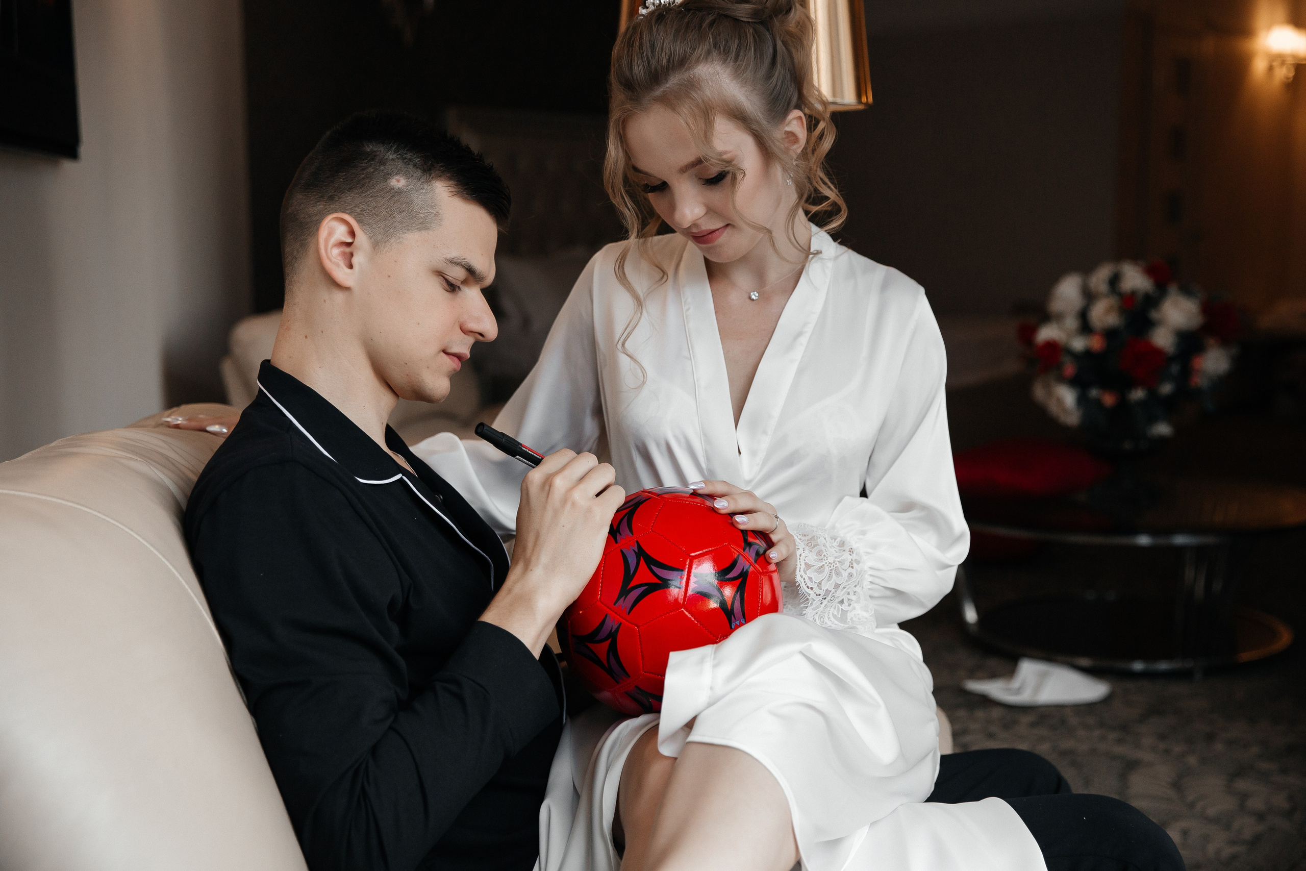 Молодожены расписываются на футбольном мяче