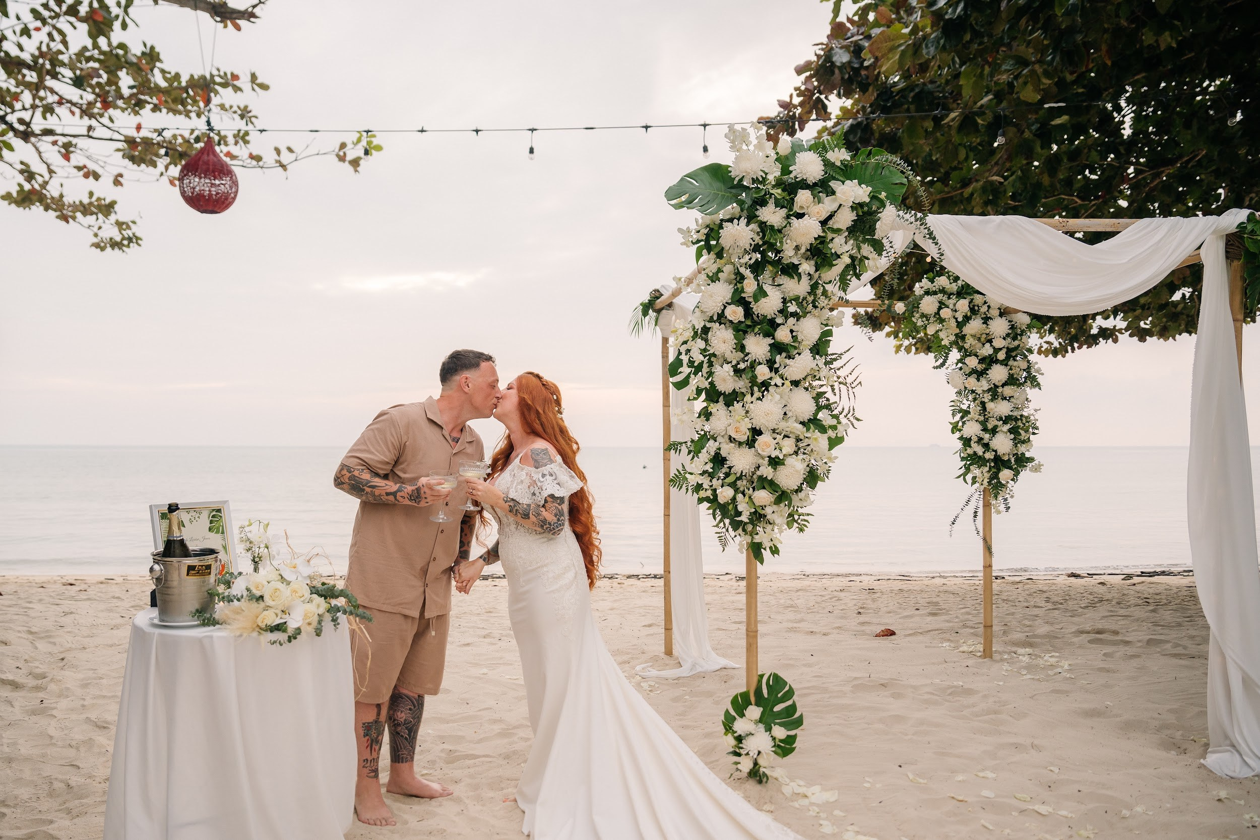 Elegant beach wedding setup on Koh Samui, Thailand with bride, groom, flowers and stunning sea backdrop