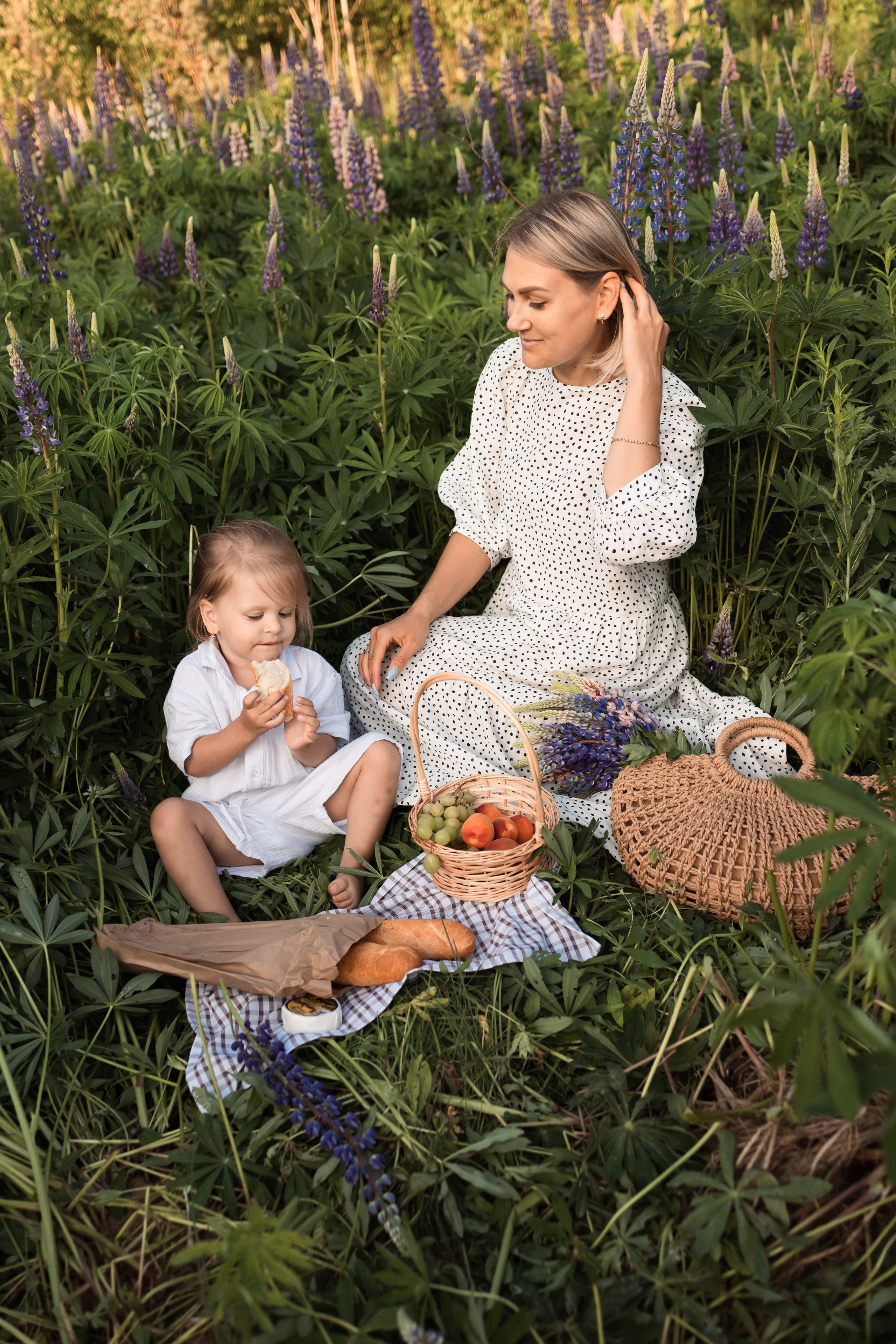 пикник мамы и дочки на поляне с люпинами
