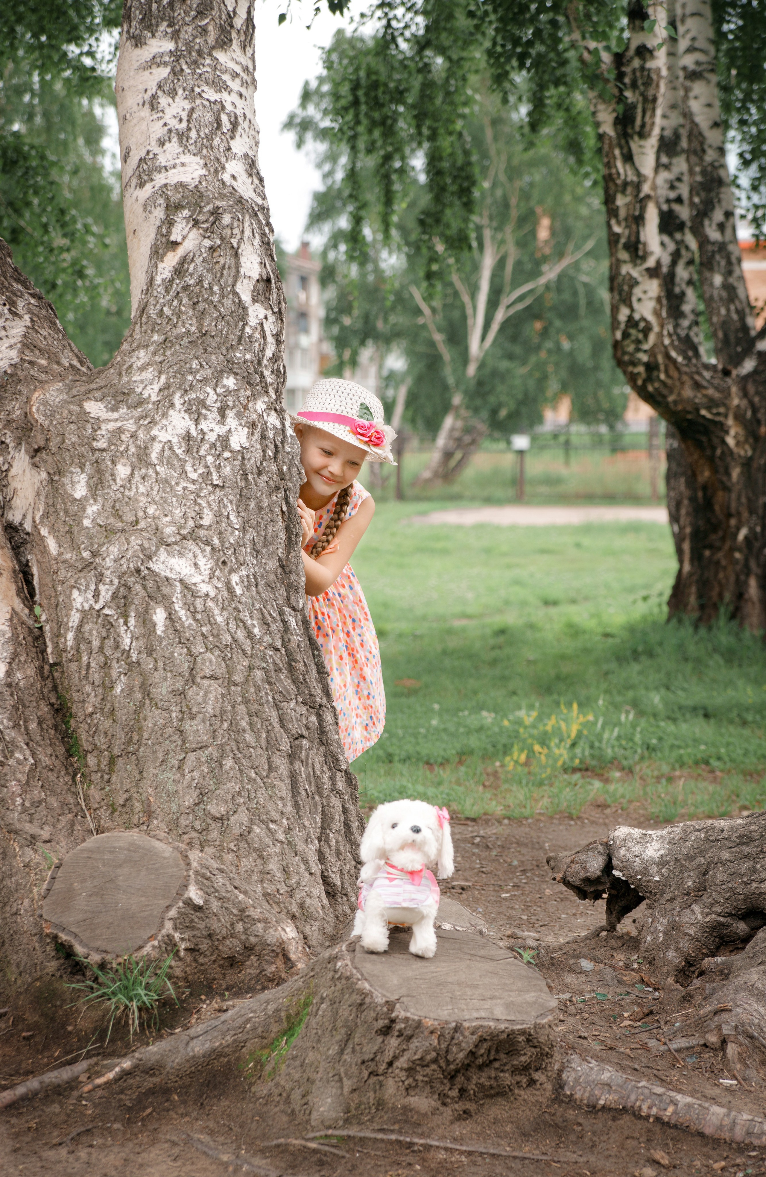 Детская фотосессия летом - девочка играет в прятки со щенком