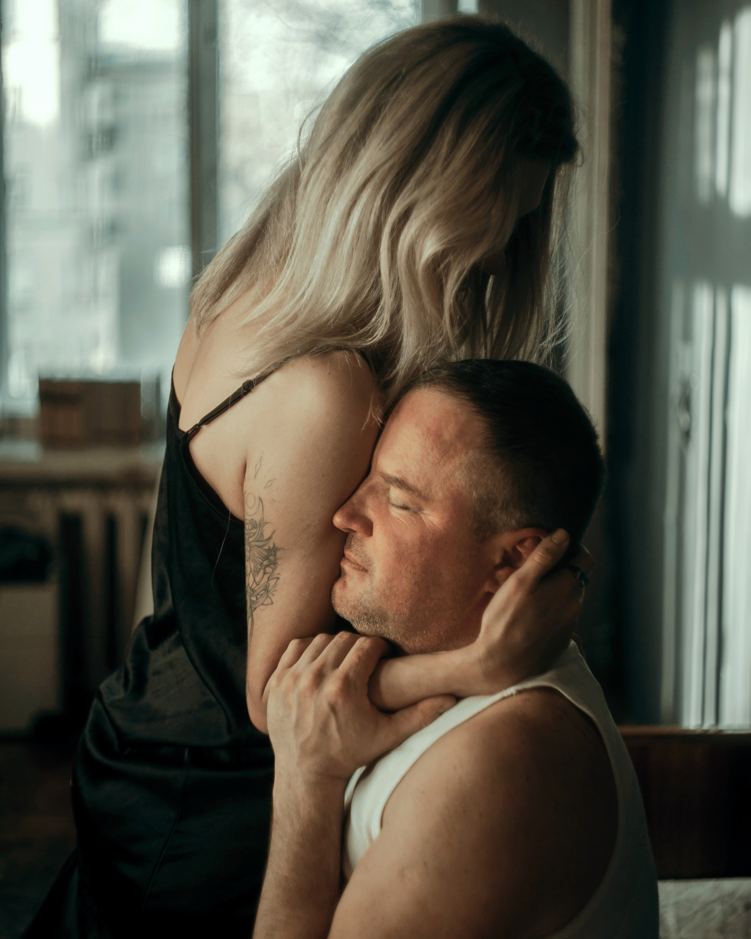 Эмоциональный портрет пары в интерьере, девушка обнимает мужчину, авторская фотосессия love story с глубоким настроением