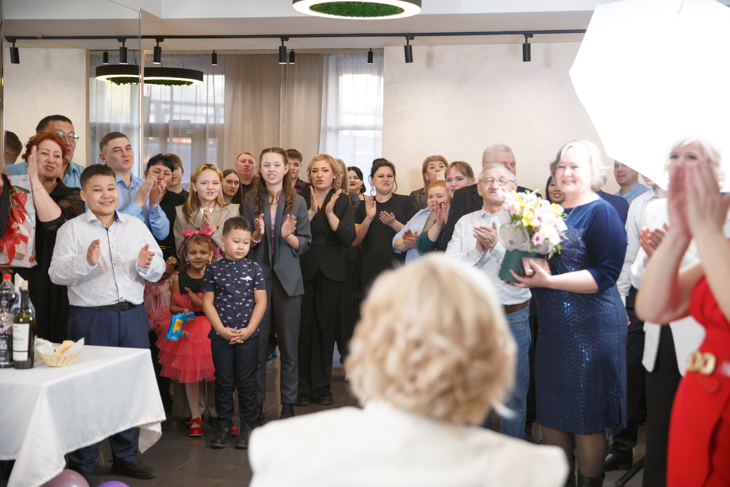  Гости аплодируют стоя, праздничная атмосфера.