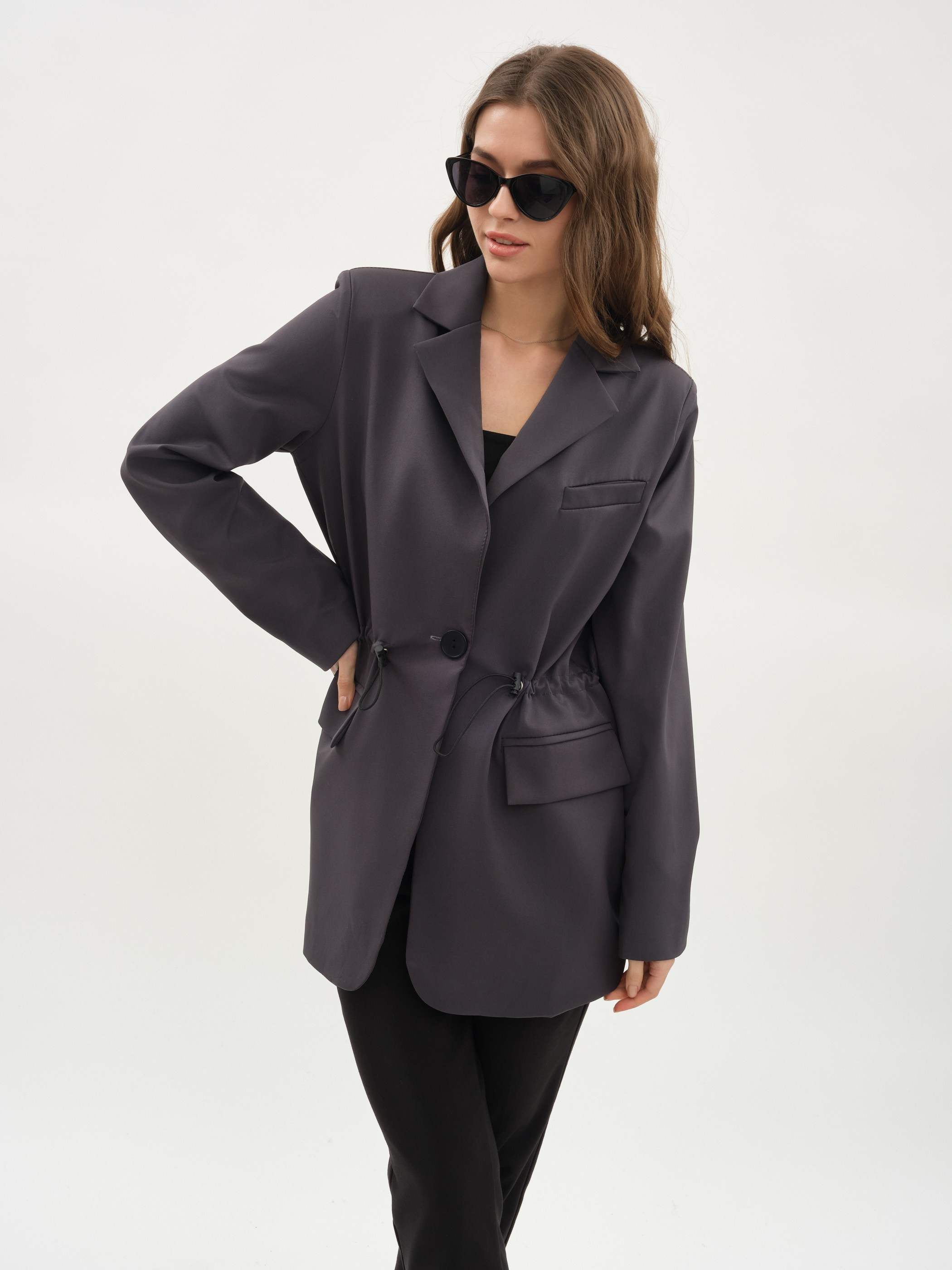Девушка в темных очках и темно сером пиджаке