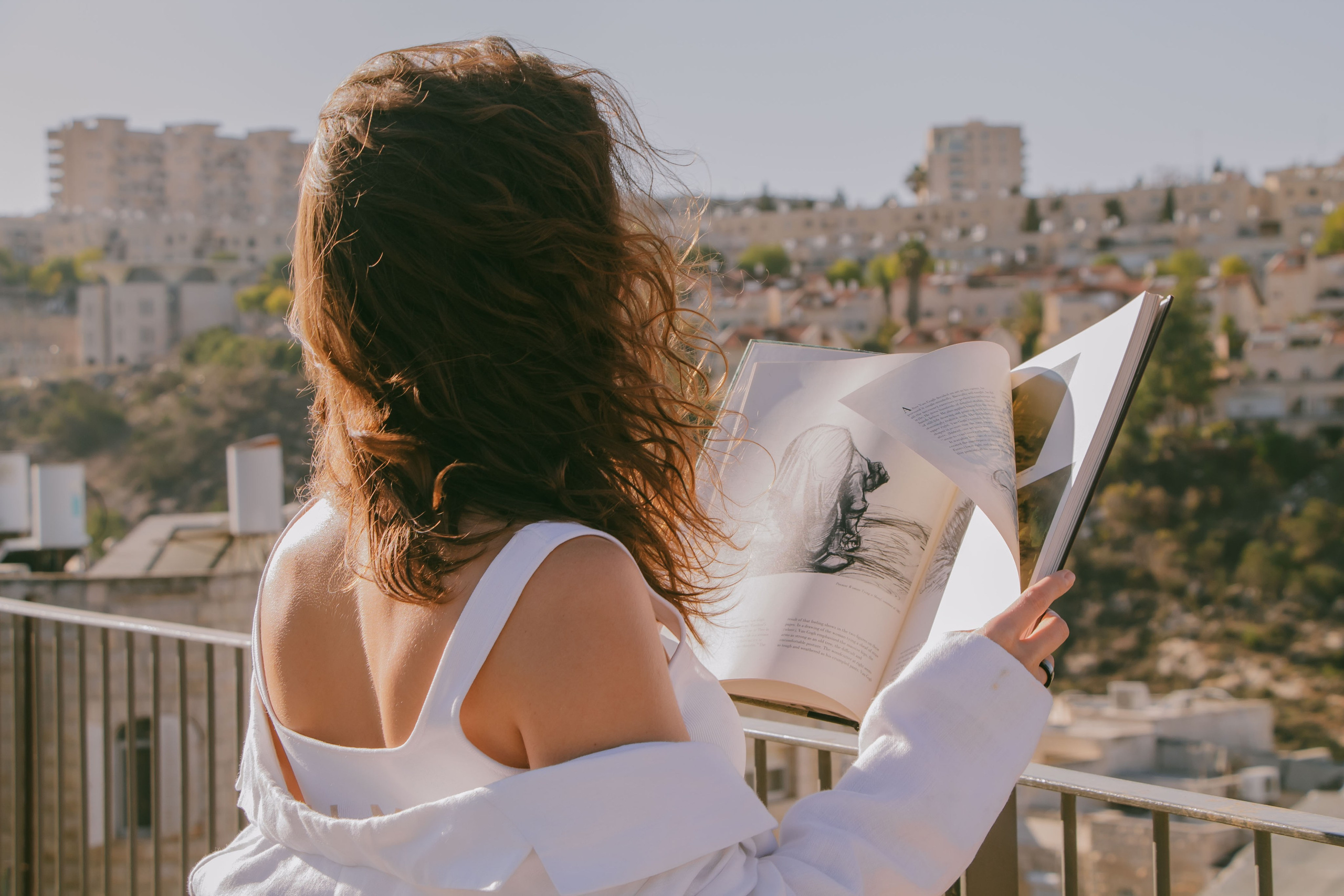 девушка с кудрявыми волосами и с раскрытой книгой