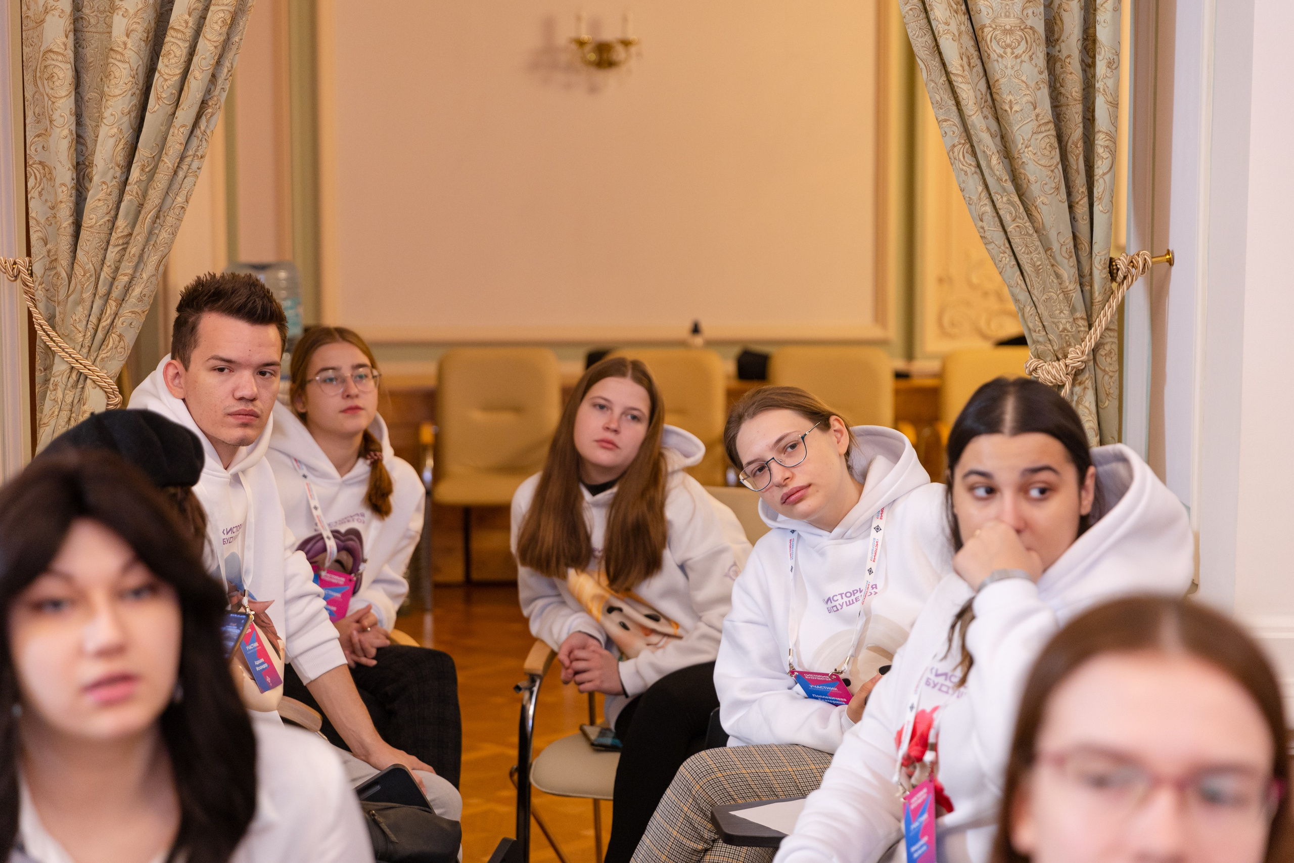 Участники чемпионата сидят на  стульях в аудитории.