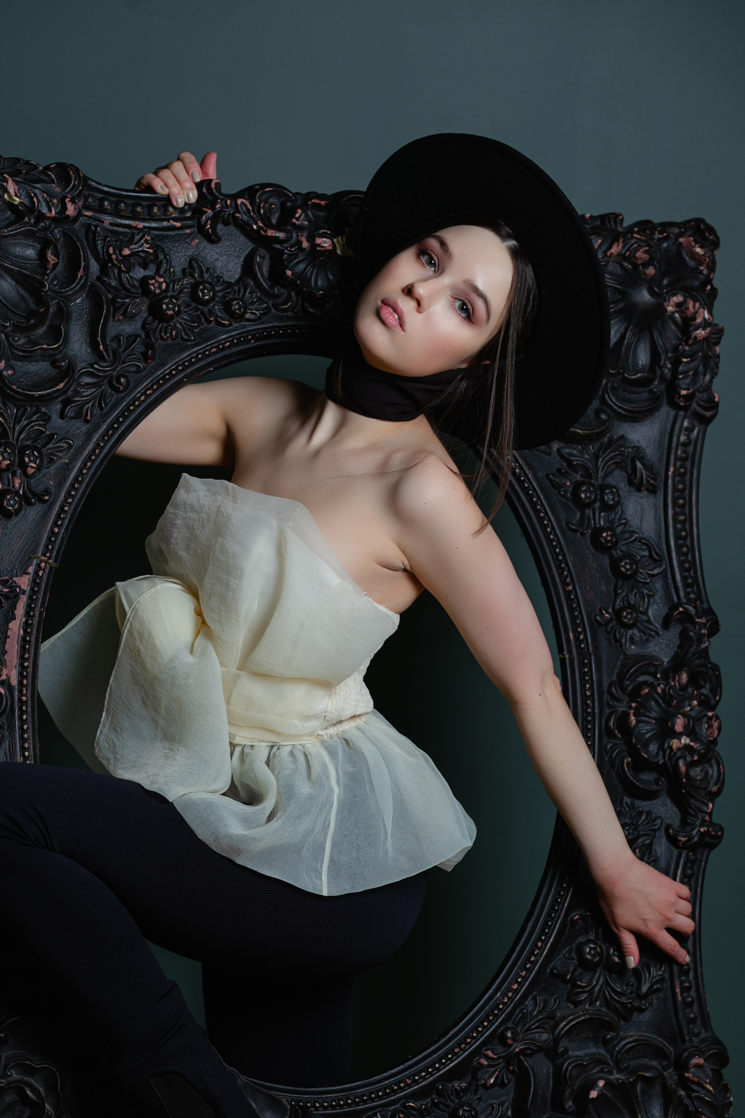 Девушка в чёрной шляпе и белом платье внутри картины