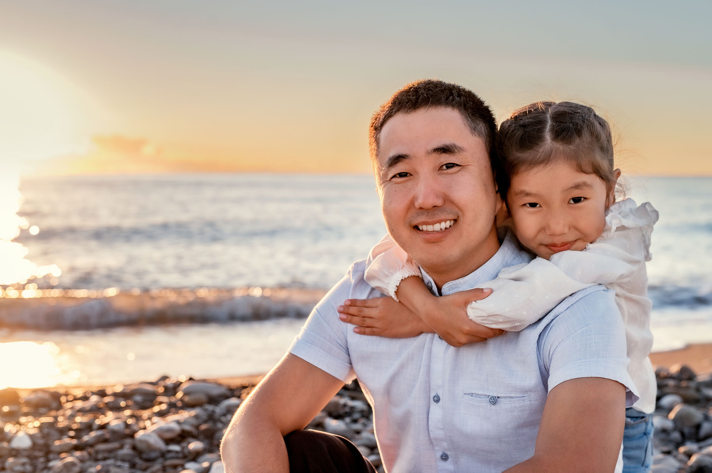 Папа и доча на черном закатном море.