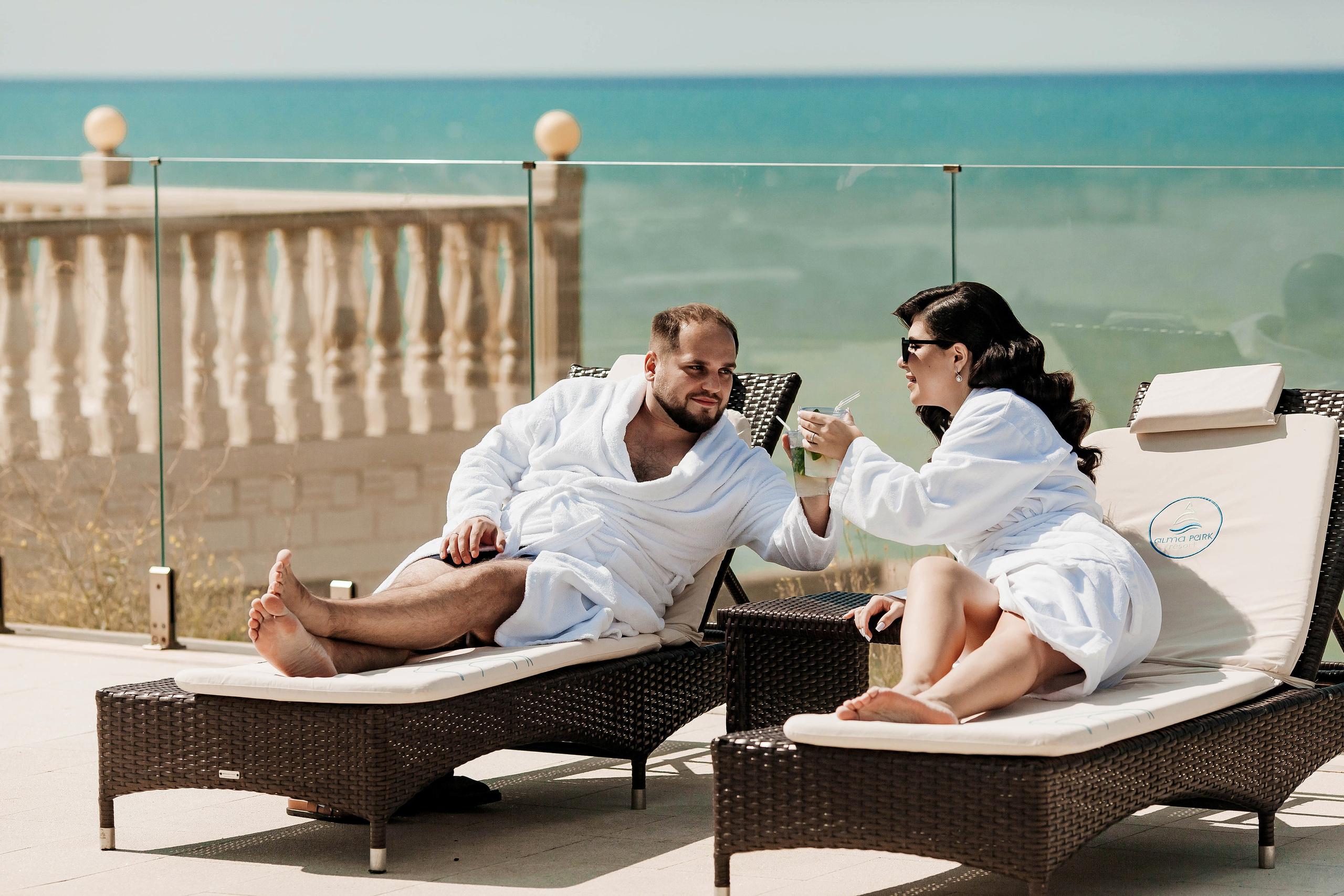 пара отдыхает на шезлонгах около бассейна 