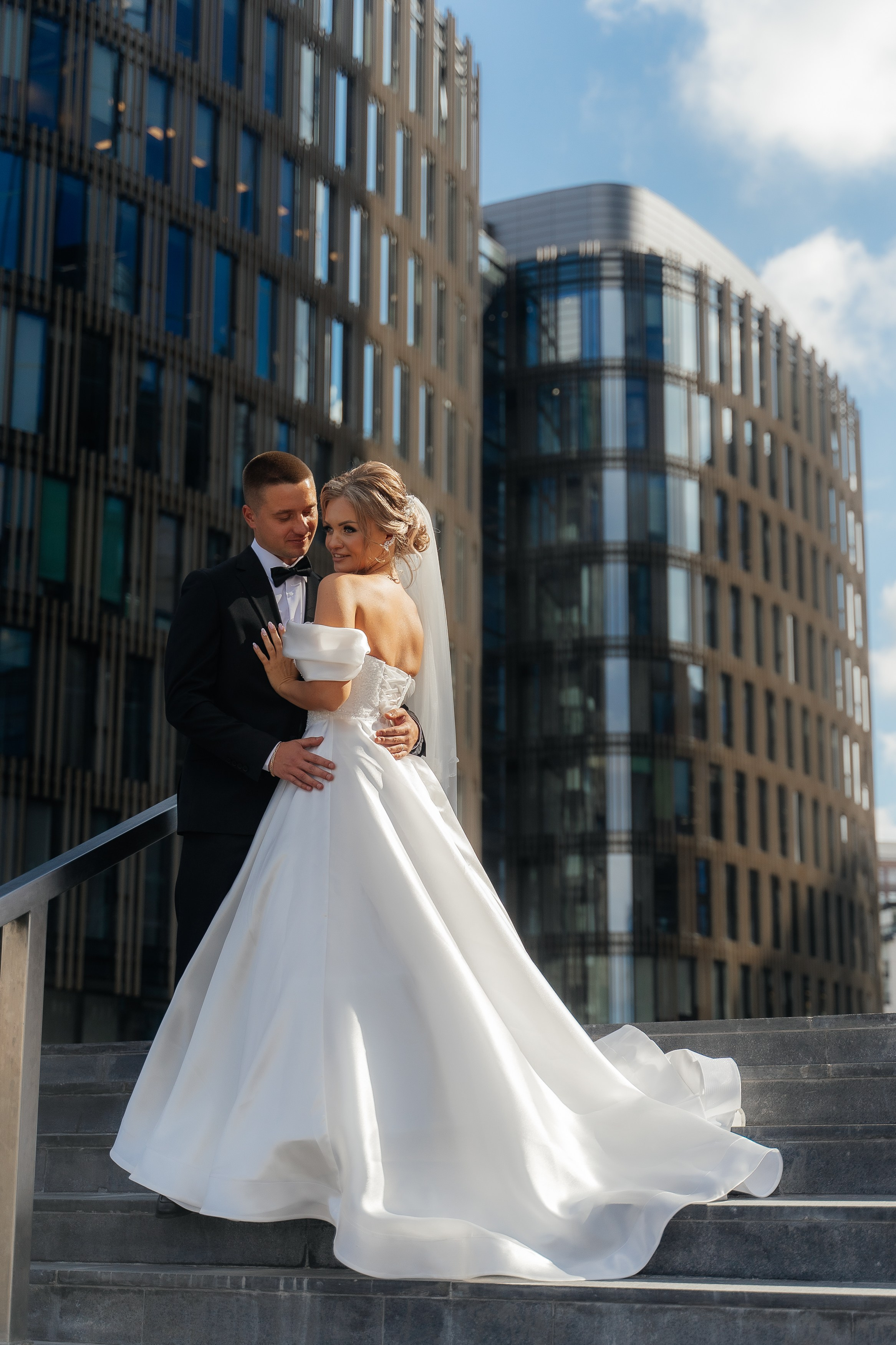 жених и невеста обнимаются около здания Банка санкт-Петербурга