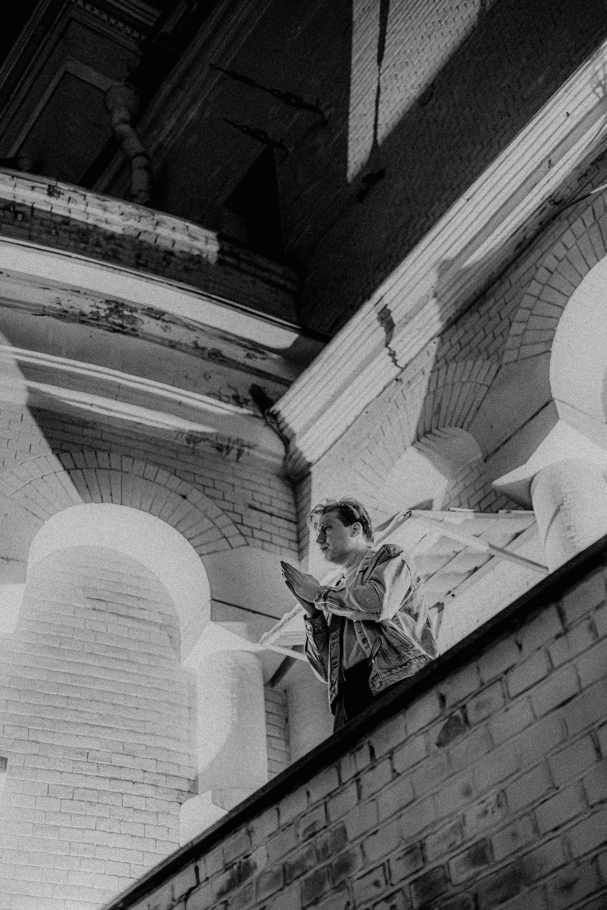 Мужчина сложил руки у церкви ночью