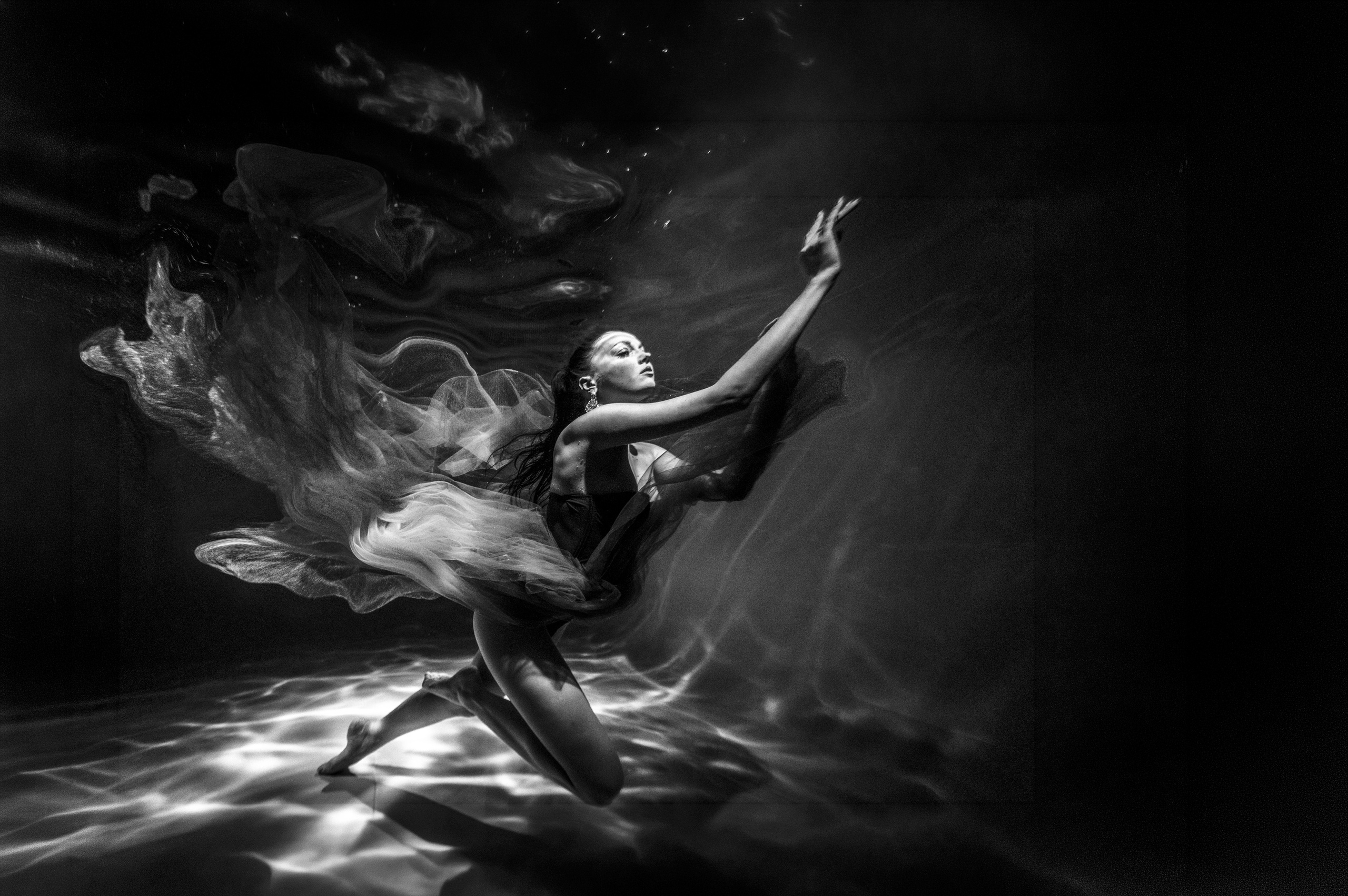 Подводная съемка девушки, плавные линии тела и ткань в движении в воде