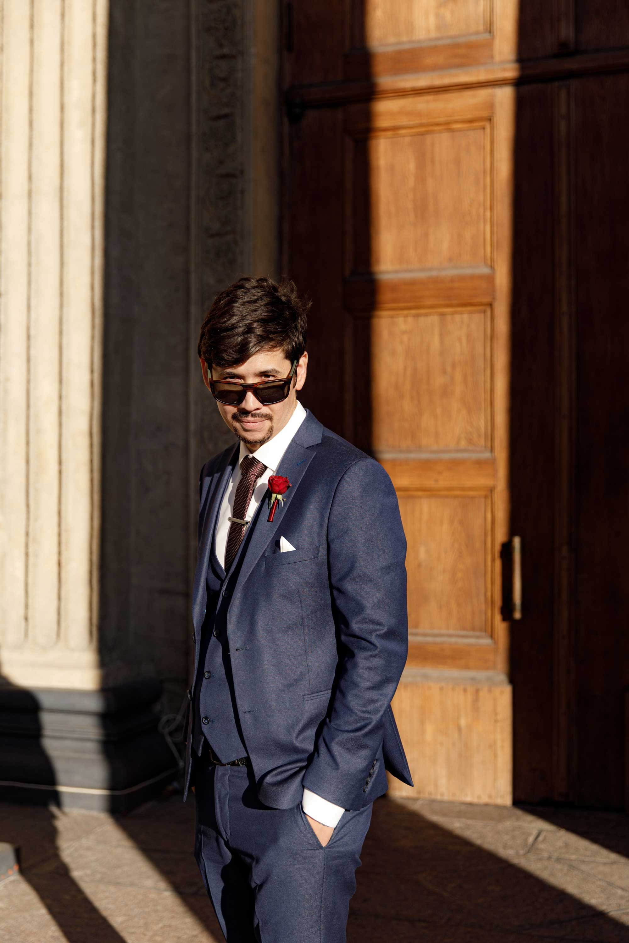 Жених в солнечных очках стоит на солнце